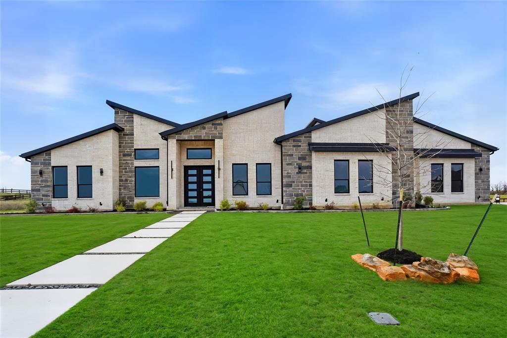 Luxury living meets unmatched privacy on this stunning 1-acre corner homesite in the Highlands of Northlake, backing to more than 300 acres of scenic farmland. This beautifully designed new construction offers 3,872 square feet of modern architecture, open living spaces, and thoughtfully curated finishes throughout.
Step inside to soaring ceilings, wide plank wood flooring, and expansive windows that fill the home with natural light. The spacious living room anchors the home with a striking floor-to-ceiling fireplace and sliding glass doors that seamlessly connect indoor and outdoor living.
The chef’s kitchen is designed to impress, featuring a dramatic waterfall island, custom cabinetry, Level 6 quartz countertops throughout the home, designer lighting, high-end appliances, and an oversized walk-in pantry. The kitchen flows effortlessly into the dining and living areas, creating an ideal layout for entertaining.
The private primary suite offers a spa-inspired retreat with a freestanding soaking tub, oversized glass shower, separate vanities, and a massive walk-in closet.
Additional spaces include a dedicated home office, formal dining room, and a versatile bonus room that can function as a game room, media room, or additional living space.
Step outside to the covered patio overlooking the expansive backyard and wide-open farmland views. The outdoor kitchen will be completed prior to closing, creating the perfect setting for outdoor entertaining. Fencing will also be installed prior to closing.
A spacious three-car garage and large laundry room add convenience and functionality to this beautifully designed home. Enjoy peaceful country views while remaining just minutes from shopping, dining, and major highways.