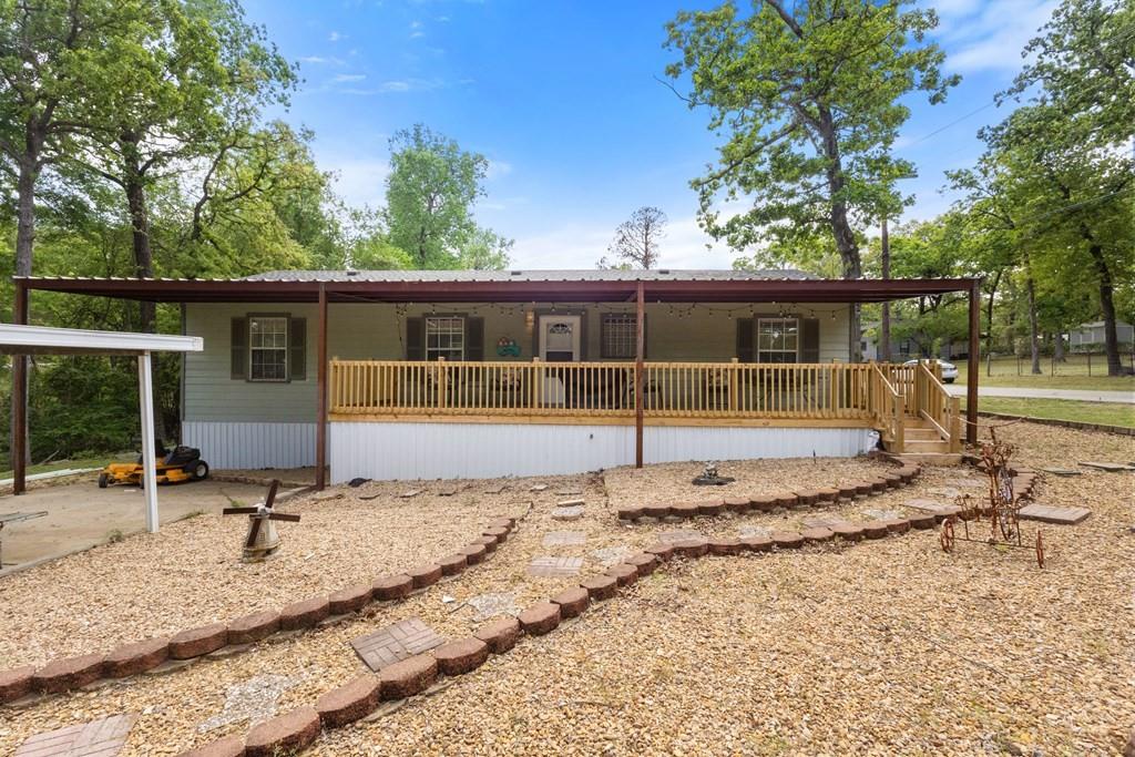 Nestled just steps from Cedar Creek Lake, this charming 3-bedroom, 2-bathroom residence in Tool, TX, offers an ideal blend of comfort and privacy. Spanning over four lots, the property covers approximately 0.42 acres, with lots of shade from tall timbers. The home offers 1411 SF and boasts split bedrooms, a spacious living and dining area with lots of windows that offer lots of natural lighting, a convenient laundry room, and a relaxing front patio with over 400 square feet of outdoor space, perfect for family gatherings or enjoying lake views. The property features a rear ramp entry for easy access and a detached two-car workshop adjacent to the house. Additionally, there is a larger workshop equipped with a cement floor, installation, 220-volt power outlets, and a roll-up door. The expansive yard is designed for easy maintenance and offers ample space. Conveniently located just minutes from the POA Boat Launch and Park at the end of the street, this property serves as an excellent Cedar Creek Lake getaway without the hefty price tag. It is ideal for both full-time living and weekend retreats, with ample room to store your boat, jet skis, or hobby shop—additional Lot across the road available.