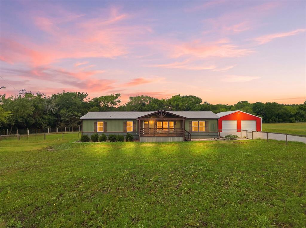 Situated on 5.25 acres, this property offers a peaceful country setting complete with a creek that runs through the property, a man-made pond, and plenty of space to enjoy. The well-maintained 2018 manufactured home features approximately 2,000 square feet with 4 bedrooms, 2 bathrooms, and an open-concept layout designed for comfortable everyday living. Built with upgraded 2x6 exterior walls, added insulation, and a metal roof, the home offers both durability and efficiency. Inside, you’ll find 2 spacious living areas, large kitchen, dining area, oversized laundry room, and a huge primary suite with an attached primary bathroom. Enjoy the outdoors from the large covered front porch or oversized back deck overlooking the property. The front yard is fenced, with partial fencing around the acreage. The 30x40 shop, built in 2020, includes electric and a 10x40 overhang with plenty of space for vehicles, boats, side-by-sides, equipment, storage, or workshop use. Located in Trenton ISD, this property combines the privacy and charm of country living with convenient access to nearby towns and amenities.