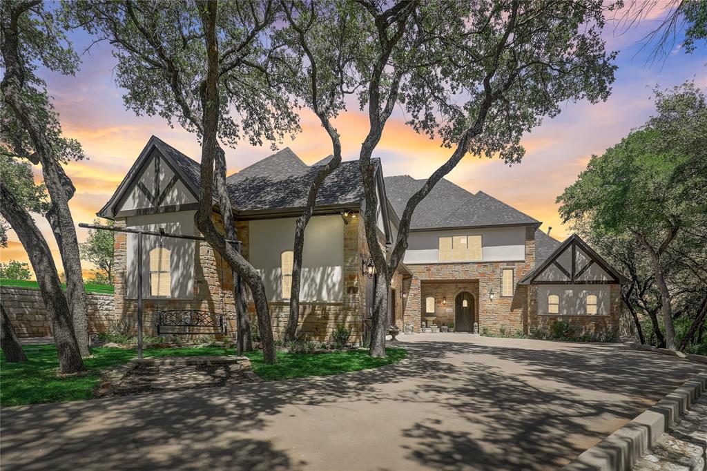 IINCREDIBLE VIEWS! OVER 150FT OF LAKE FRONTAGE! Nestled on the shores of Lake Granbury, this is the house for your discerning buyer looking for their home or weekend getaway. The open floor plan invites you into a space adorned with stone walls crafted from genuine Granbury stone. Klipsch Audio speakers throughout. Host a movie night in the theater or relax by the natural gas fireplace with remote. The gourmet kitchen features hand-built white oak cabinetry, Taj Majal granite countertops, Gaggenau built-in refrigerator freezer, Bertazzoni commercial range and Dacor microwave. The owner's suite features sliding antique hardwood doors leading to the spa-like master bath, complete with a custom-built oak cabinetry and a sitting area opening onto the pool deck. On the 3rd floor discover a spacious office suite with a balcony overlooking the lake. Outdoor living is amazing with a wireless motorized patio screen system and custom speaker system perfect for entertaining guests by the pool.