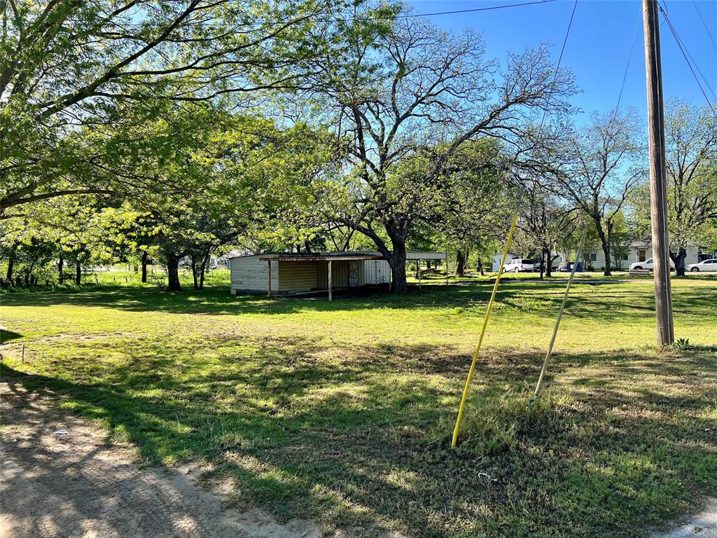 Picture perfect corner lot with pretty shade trees to surround your ideal home. Great opportunity for a site-built home & room for a shop as well. Carport & storage already in place. This lot is located just a few blocks from the famous Nocona Enid Justin City Park. Just one block from the schools.  This corner would make a great commercial location with 2 street access for an easy in & out operation and no zoning. Pick your choice or choose both as the lots offers room to enjoy.