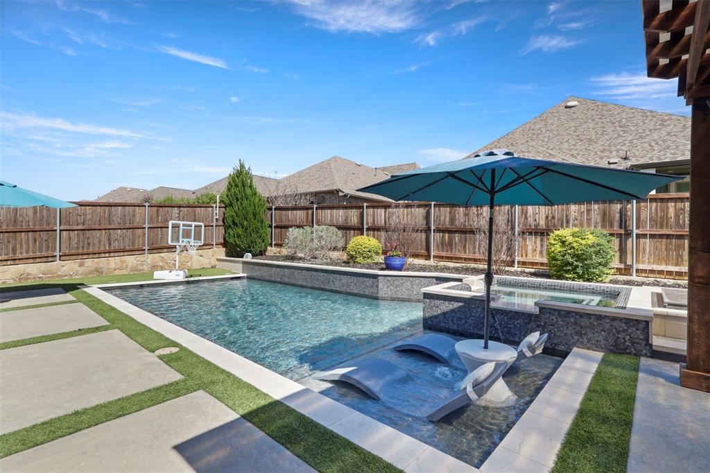 BETTER THAN NEW!!  Stunning upgraded home with resort-style backyard oasis! This beautifully maintained 4-bedroom, 3-bath home offers the perfect blend of luxury, comfort, and turnkey living. Rich hardwood floors throughout, plantation shutters on every window, custom chandeliers, and designer lighting create a sophisticated yet inviting atmosphere from the moment you walk in. The gourmet kitchen is a dream for entertaining and everyday living, featuring extensive upgrades and opening to a bright breakfast room surrounded by beautiful windows overlooking the backyard retreat. The home also includes whole-home audio, central vacuum, and a whole-home water softener with reverse osmosis for elevated daily living. Step outside to your private resort-style outdoor living space featuring a spectacular saltwater pool and spa, perfect for relaxing or entertaining. Enjoy evenings under the pergola-covered patio, gather around the gas fire pit, and appreciate the beauty and convenience of low-maintenance artificial turf with no backyard grass. The luxurious primary suite features a spa-inspired bath with frameless glass shower, modern finishes, and generous vanity space. A dedicated home office with built-in desk and shelving makes working from home effortless. Additional highlights include an insulated garage with epoxy flooring and heavy-duty storage shelving. With designer upgrades, model-home quality finishes, and an entertainer’s dream backyard, this home offers luxury living inside and out and is truly move-in ready. Nestled in the desirable Sandbrock Ranch, this home offers residents access to resort-style amenities such as sparkling pools, fun playgrounds, and picturesque trails. It’s the perfect combination of comfort, practicality, and vibrant community living. Backyard oasis • Saltwater pool & spa • Hardwood floors throughout • Plantation shutters • Designer upgrades • Entertainer’s dream!! Solar panels and whole home battery backup will be paid off at closing.