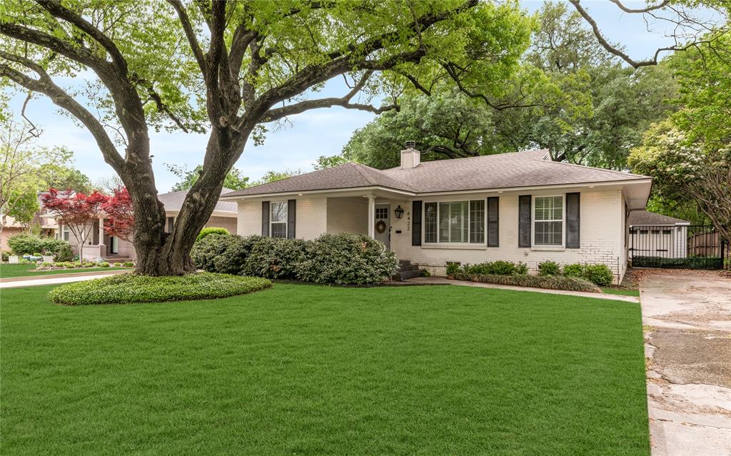 Nestled on an oversized, tree-shaded lot in the heart of sought-after Ridgewood Park, this beautifully updated home offers timeless charm paired with modern comfort. Surrounded by mature trees and situated on a peaceful street, the inviting exterior sets the tone for the warm, welcoming spaces found inside. The open-concept floor plan is filled with natural light and highlighted by rich hardwood flooring, plantation shutters, and a striking gas fireplace finished with German smear brick. The spacious living and dining areas connect seamlessly to the kitchen, making everyday living and entertaining effortless. The kitchen is thoughtfully appointed with granite countertops, stainless steel appliances, a classic tile backsplash, updated fixtures, and ample workspace. French doors open to an expansive deck overlooking one of the neighborhood's standout backyards. Offering exceptional privacy beneath towering shade trees, the outdoor living space is ideal for hosting friends, relaxing with family, or enjoying quiet evenings surrounded by nature. The primary suite provides a comfortable retreat with a private bath, while the generously sized secondary bedroom is served by an updated full bathroom. Extensive improvements have been completed over the years, including a replaced HVAC system, rebuilt deck, enhanced landscaping, French drain installation, relocated interior laundry area, exterior water shutoff valve, and updated kitchen appliances including the stove and dishwasher. The detached two-car garage has been upgraded with new siding, added insulation, a redesigned peaked roof, additional windows, and an electric gate for secure access. Located just minutes from Ridgewood Park, the neighborhood splash pad, scenic trails, and all that East Dallas has to offer, this move-in-ready home combines classic character, quality updates, and an exceptional outdoor setting in one of the area's most desirable neighborhoods.