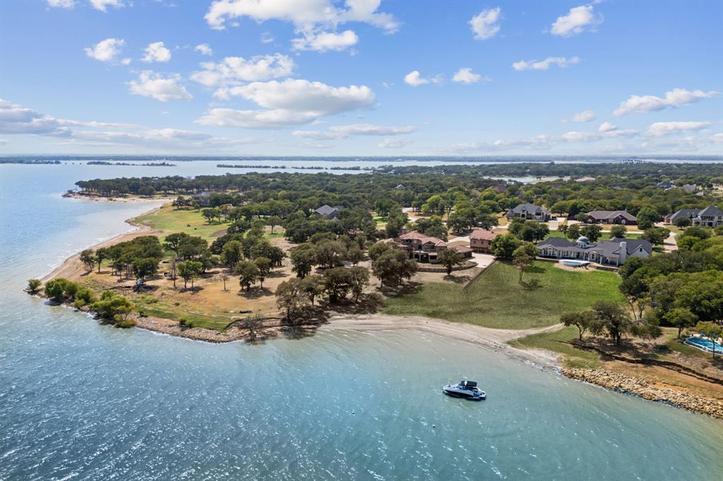 Huge price reduction to move fast!  Priced BELOW recent appraised value this is a must see, won't last!  Experience unparalleled lakefront living on a breathtaking 1.6-acre estate offering some of the most spectacular panoramic water & city views in North Texas. This rare & coveted property—recently featured in the Dallas Morning News—is one of the only homes on the lake with deep water access, a private sandy beach, & a new infinity edge pool. This small enclave of prestigious estates has seen recent sales exceeding $4 million, making this home an incredible opportunity at under $2.5 million & only 30 minutes to DFW.
Nestled atop “The Hill,” this iconic estate boasts over 5,000 square feet of meticulously designed living space at its best.  With deep water moorings - boating is from the backyard. Almost every inch of this home has been transformed, from the designer-renovated primary suite & chef’s kitchen (featuring 5 cm quartz countertops) to the new pool in the back yard. Truly turn key. With almost 800 sq ft unfinished space, brings the total square feet to just under 6000! Room for boat house or guest house is also possible.


Deep water moorings for effortless boating access
Sandy beach for serene lakeside relaxation
Sprawling backyard with resort-style pool overlooking open water
Unrivaled privacy & elevation—high & dry lake living at its finest
Enjoy a tight-knit, golf cart-friendly community just 30 minutes from DFW Airport & be among the first families in the new neighborhood elementary school.

This is more than a home—it’s a legacy property where luxury meets waterfront tranquility. Don’t miss your chance to own one of the most exceptional estates on the lake.  Schedule your private tour today!  NOTE: The City of Lakewood Village is updating the entrance with a large monument sign with water feature.  It's a huge update, see documents in transaction desk!