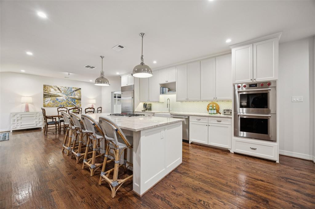 Set on a beautifully landscaped corner lot in the heart of Windsor Park, this timeless ranch offers an elevated blend of sophistication and comfort. Inside, every detail has been thoughtfully designed, from the dual primary bathrooms with custom closets to the expansive living areas filled with natural light. The kitchen is a true showpiece with Taj Mahal quartzite countertops, Sub-Zero refrigeration, and Wolf appliances, all anchored by a large island perfect for gathering. The floor plan flows effortlessly, offering multiple living and dining spaces, spacious secondary bedrooms each with en suite baths, and a private primary retreat that feels like a sanctuary. Outdoors, a sparkling pool, covered patio, and lush green space create a resort-style setting ideal for entertaining or quiet relaxation. With its classic white brick exterior and mature trees, this home combines charm and modern luxury in one of Dallas’ most coveted neighborhoods—just minutes from top private schools, shopping, and dining.