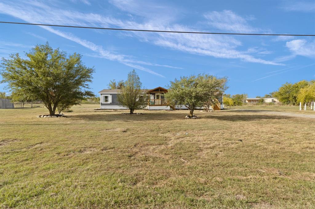 Looking to be home for the holidays? This spacious 5-bedroom home on a generous 1-acre lot has enough room for everyone! Recent upgrades include a new roof and skirting, 2023 HVAC, a fresh coat of paint inside and out, and newly updated flooring. The dreamy white kitchen boasts new granite countertops and tiled backsplash, stainless steel appliances, and an island. Windows flood the home with natural light, and the wood burning fireplace in the living room is a cozy place to gather on these chilly evenings. The family room could be a formal dining area, office space, or music room. The layout offers privacy with split bedrooms, and the generous master suite with soaking tub is a true retreat. The 2nd and 3rd bedrooms share a jack n jill bath, and bedroom 3 has private exterior access. The separate laundry has space for a freezer and opens to the delightful covered deck spanning almost the entire length of the back of the home. Conveniently located near Chisolm Trail in Godley ISD.