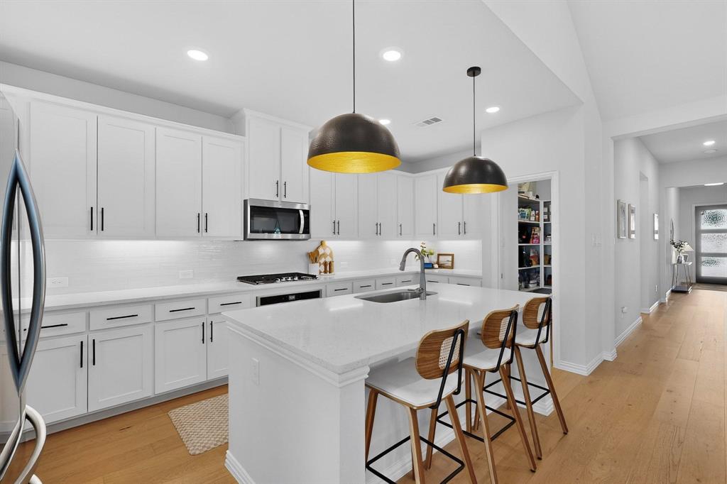 BUILDER CAN'T TOUCH THIS: $10,000 Spend It Your Way Offer! NEAR NEW HOME FOR UNDER $420k! This 2024 FOUR-BEDROOM, dual-ensuite home in Reunion offers a serene, design-forward lifestyle. You'll love the BONUS ROOM which adapts beautifully as a home office, creative studio, media lounge, or play space without sacrificing a bedroom. SPACIOUS HALLWAYS and OPEN LIVING SPACES are anchored by NATURAL LIGHT OAK FLOORING and abundant daylight, creating a calm, welcoming atmosphere throughout. Don't miss this STUNNING KITCHEN featuring Nuvo QUARTZ, Black Iron Hardware, Golden-Dome Pendants, gas cooktop, an Expansive Island w.sink or the GINORMOUS PANTRY. The adjoining family room is wrapped in windows that frame peaceful outdoor views along with a GAS FIREPLACE. Dining is a dream in this setting, including a functional BUFFET NICHE. Positioned for privacy at the rear of the home, the primary suite is complete with a spa-inspired SOAKING TUB, custom shower, and a THREE-TIERED walk-in closet ~ insert jaw drop! A 2nd TIMELESS ENSUITE—styled as a tranquil nursery—pairs refined architectural detail with WARM, ORGANIC TONES, creating a space that evolves effortlessly thru childhood or supports an in-law. Across the hall, enclose two additional bedrooms and the central hall bath to CREATE A THIRD SUITE for any age or purpose. Outdoors, a COVERED LIVING SPACE extends the home’s livability, perfect for stillness or gatherings. REVIEW the IMAGE with UPGRADES EXCEEDING $75K in the 2026 version! Beyond your door, Reunion’s LAKE ELOISE beckons with fishing, walking trails, a vibrant amenity center and amphitheater. Professionally curated events foster a connected, outdoor-forward lifestyle—where sunsets are savored, neighbors gather, and evenings often end beside an outdoor fireplace. Country-side vibe located within award-winning NWISD, with HWY 114+287 ACCESS to Alliance and DFW Airport. Phase 1 is complete, with future on-site schools and over 10,000 homes planned. REUNIONTX dot com