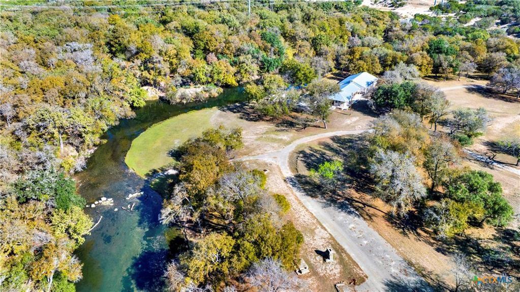 Horseshoe Falls, A Historical Lampasas Gem! Also known as Gunderland Park, a sprawling 378-ac high-fenced ranch. This is a very rare opportunity to own both sides of Sulphur Creek, as it flows year-round through the ranch. Be transformed to another world with the abundance of native tree cover, wildlife, and the sounds of living water. Adored by many, locals can recall fond childhood memories of fishing and camping here. An original merry-go-round and hand-built rock BBQ pits, benches, and tables still remain intact. An upper pasture blooms with sunflowers, attracting quail hunting enthusiasts. Most recently, this one-of-a-kind property is being used as an exotic ranch, serving guests with exclusive hunts and catered private events. The ranch's centerpiece is a spacious 2,500+ sq ft 1.5-story primary home with 4 bedrooms, 2 bathrooms, and two living areas, offering breathtaking views and sounds of the ever-flowing Sulphur Creek dam. This site holds important significance as Captain J.F. Brannon of the Ninth Infantry commissioned 193 men to build the Lampasas State Park & Dam in June 1933. Beyond the main residence, discover a 2400 sq ft., climate-controlled main hall overlooking the live water of Sulphur Creek, equipped with restrooms and a rustic rock fireplace upon entry. Perfect for weddings, private or corporate events, or private family get-togethers. Capable of seating up to 150 people comfortably around dining tables, with additional seating outside on the rock patio. Additionally, there are six fully restored and uniquely decorated cabins. All with unique themed decor with names such as: The Ranger Station, Bass Bungalow, Birds Nest, Tee Pee, La Cabana & of course, the JAIL. Most cabins sleep 2-6 guests with full bathrooms.  A Lodge, aka The Horn Room is equipped with a full kitchen for serving a larger party of guests at once. Enjoy a game of pool or darts in the game room. Pictures and words cannot adequately describe this unique paradise.