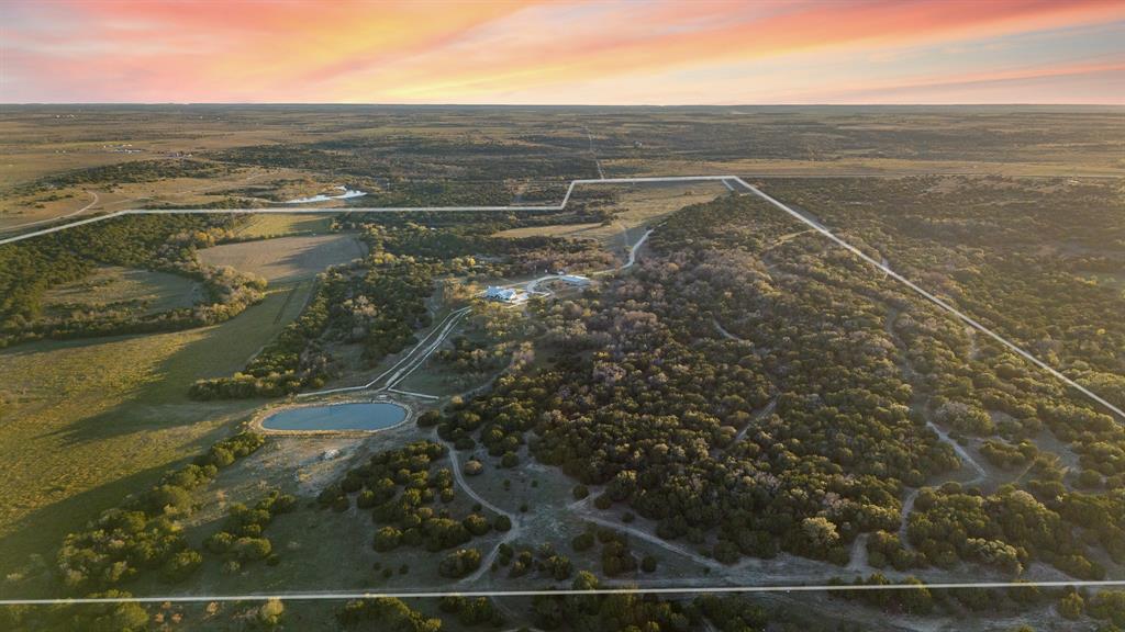 This ranch is the perfect recreational property with excellent hunting and fishing.
Alexander Creek runs north and south through the property, with a spring-fed pond, a second pond built in 1998, and a third pond 1.5-acre lined pond (fully stocked) located just below the main home providing great swimming holes, superb fishing, and plenty of water for wildlife. 
The main home is 3,600 sf., 3-bed, 2.5 bath, has a gas fireplace, huge game room, and wrap-around porch overlooking the countryside!  It comes fully furnished with a full-size generator, high-efficiency HVAC, spray foam insulation, and landscaped yard with sprinkler system.
The property is high fenced with 3 water wells, cattle pens, a pole barn, and 2 Premium Deer Blinds.
40 x 75 metal workshop insulated with 3 O.H. doors, 2 walk-thru doors, heavy duty electrical, hot and cold water, and 5 H.P. Rotary Air Compressor
The second home is 4-bed, 2-bath home that was moved from Baylor campus in Waco to the property in 1962.