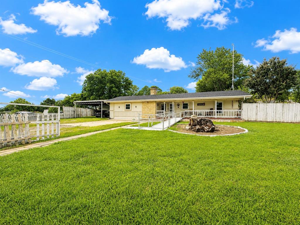 Discover the relaxed lifestyle of Lake Tawakoni at 245 Harris Harbor! Located within walking distance of the lake, this spacious property sits on a large corner lot in the established Whispering Oaks community and offers endless possibilities for full-time living, a weekend getaway, or even a vacation rental.

With over 2,800 square feet of living space, this 5-bedroom, 2-bath home features multiple living and entertaining areas, including a spacious family room and an additional flex space that would make an ideal bedroom, media room, home office, or hobby area. The oversized kitchen is the heart of the home, showcasing a custom stone island, abundant cabinetry, natural wood accents, and plenty of room for gathering with family and friends.

Step outside and enjoy the peaceful setting from your private backyard retreat. The expansive lot offers plenty of room to relax, entertain, garden, or store your recreational toys. Outdoor enthusiasts will love the wood-fired pizza oven, outdoor sink, and dedicated space for a grill and mini refrigerator, creating the perfect opportunity to complete your dream outdoor kitchen. Multiple outbuildings with electricity provide excellent space for a workshop, storage, gardening shed, craft room, or future man cave. An oversized garage with storm shelter adds even more functionality and is perfect for boats, lake equipment, vehicles, or additional storage.

Enjoy the charm of lake-area living without sacrificing convenience. Located approximately one hour from Dallas and eligible for USDA financing, this move-in ready property offers the perfect blend of space, versatility, and access to all that Lake Tawakoni has to offer.
