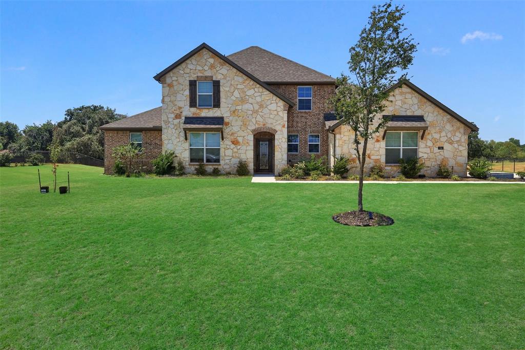 STUNNING TWO STORY HOUSE WITH FANTASTIC CURB APPEAL REFLECTED IN THE NATURAL STONE AND BRICK EXTERIOR THAT SETS ON A SPACIOUS 1 ACRE LOT IN THE HEART OF SPRINGTOWN. THIS GORGEOUS 4 BEDROOM 3.5 BATH HOME HAS MANY UPGRADE FEATURES THROUGHOUT THIS OPEN-CONCEPT LAYOUT. THE FAMILY ROOM FEATURES A GRAND-CORNER FIREPLACE AND LARGE WINDOWS FRAMING SERENE BACKYARD VIEWS. THE GOURMET KITCHEN BOASTS A GENEROUS ISLAND, STAINLESS STEEL APPLIANCES, WALK-IN PANTRY AND ADJOINING DINING AREA THAT IS PERFECT FOR BOTH DAILY MEALS AND ENTERTAINING. THE FIRST FLOOR PRIMARY SUITE IS A TRUE RETREAT WITH A DUAL SINK VANITY, SEPARATE SHOWER, GARDEN TUB AND WALK-IN CLOSET. LARGE STUDY WITH DOUBLE FRENCH GLASS DOORS. UPSTAIRS YOU’LL FIND A SPACIOUS LOFT-PLAYROOM. ALL SECONDARY BEDROOMS HAVE A DEEP CLOSET. THE OVERSIZE 2-CAR GARAGE WITH A SINGLE LARGE DOOR PROVIDES AMPLE ROOM FOR VIHICLES OR EXTRA STORAGE. ENJOY THE CONVENIENCE OF A DEDICATED STORAGE-WORKSHOP BUILDING EQUIPPED WITH ELECTRICITY PROVIDING AMPLE SPACE FOR HOBBIES, PROJECTS OR EXTRA STORAGE NEEDS. APPRECIATE THE OUTDOORS UNDER THE COVERED PATIO OVERLOOKING YOUR PRIVATE ACRE WITH PLENTY OF ROOM FOR A POOL OR GARDEN. THIS MOVE-IN READY HOME COMBINES COUNTRY CHARM WITH MODERN CONVENIECE AND ACCESS TO TOP RATED SPRINGTOWN ISD SCHOOLS. DON’T MISS OUT ON THIS INCREDIBLE OPPORTUNITY TO CALL THIS ONE HOME.