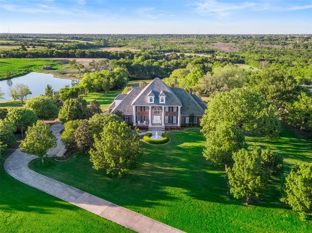 Exclusive Offer: Seller Financing at 4% plus $25K toward updates, creating an exceptional value for this gated 10-acre luxury estate in Sunnyvale ISD! Rare opportunity for buyers seeking acreage, privacy and long-term investment potential near Dallas. Enter through the electric gate and follow a winding, tree-lined drive to a private retreat designed for recreation and entertaining. The resort-style pool and spa anchor the outdoor living space, complemented by an expansive terrace with outdoor kitchen overlooking an open pasture, neighboring pond and private tennis and basketball court. Fenced pasture and a 700+ SF metal barn provide flexibility for equestrian use, hobbies or storage. Inside, the home offers generous scale and a functional layout ready for personalization. The kitchen features a SubZero refrigerator, GE Profile double ovens, walk-in pantry and nugget ice maker. A grand family room with gas fireplace, dedicated media room with GE Monogram beverage center, game room, study with built-ins and fitness room with mirrored walls provide multiple living and entertaining spaces. The primary suite overlooks the pool and includes a Kohler jetted tub and Mr. Steam shower. An oversized 4-car garage with epoxy flooring, slat wall storage, workshop space and built-in safe enhances functionality. Approximately 10-acres with mature trees, open pasture and dedicated walking paths with custom lighting create a rare combination of luxury amenities and usable land. Seller financing available to qualified buyers. Enjoy the benefits of Sunnyvale ISD, known for its 100% graduation rate and ‘Superior Achievement’ financial rating, while embracing the privacy and lifestyle this estate delivers.