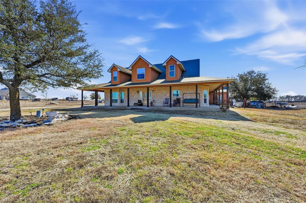 Welcome through the private gate to a custom ranch-style property set on 10 AG exempt expansive acres offering seamless indoor-outdoor living, amazing views, and amenities that support both relaxation and productivity. The wraparound covered porch and upper level walk out deck, creating an undeniable connection to nature, offers the ideal spaces to enjoy sunrises and sunsets. The heart of the home features a chef-inspired kitchen with handcrafted cabinetry, dual sinks and dual ovens perfect for hosting gatherings.  The primary bedroom with ensuite bath features 2 walk in closets and a jacuzzi tub. Multiple access points from the primary bedroom, living room, and laundry room allow you to move effortlessly between indoor comfort and outdoor freedom. An oversized laundry room with a sink and door offers a smart indoor-outdoor transition space after a long day being outdoors. Three generous sized upstairs flex rooms provide multi-functional living spaces such as home office, reading retreat, art studio, fitness room, game room, the options are endless. 

The property includes a 40x30 RV covered pad, a 40x30 workshop with electric and water also with a 40x20 attached covered patio, a three-car garage with covered access and upstairs air-conditioned storage, cross fencing, and two shipping containers with overhead metal covering offering weather protection for livestock and storage. Whether managing machinery, livestock, or recreational vehicles, this property is built to support your lifestyle. For peace of mind, the property includes 8 hardwired security cameras and a steel access gate with keypad and remote entry system. 

This is more than a home - it’s a complete indoor-outdoor living experience where privacy, functionality, and natural beauty come together. 

Refrigerator, washer, dryer, security cameras convey with sale. Machinery and livestock negotiable separately with owner.