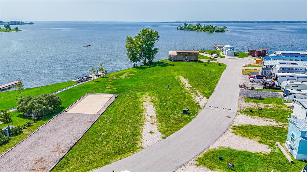 Welcome to your own slice of lakefront paradise at the upscale RV and tiny home resort on stunning Richland Chambers Lake. This premier lot features a RV pad already in place—just bring your RV and start enjoying breathtaking open-water views. With the lake surrounding you on three sides, you’ll catch both sunrises and sunsets in a truly serene setting. The resort-style community offers exceptional amenities, including a clubhouse, swimming pool, laundry facilities, outdoor grill stations, playground, dog park, fishing pier, and cozy fire pit areas perfect for unwinding while watching the sunset. Embrace the lake life you’ve been dreaming of—your waterfront getaway awaits!