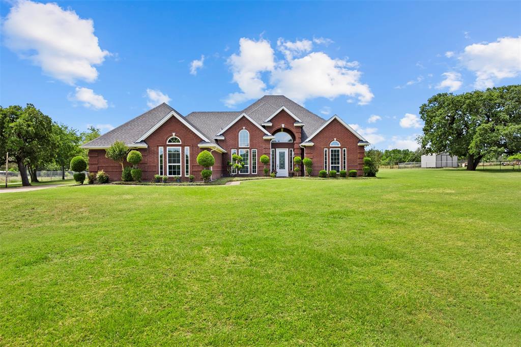 RARE opportunity to own nearly 3 ACRES of beautifully maintained property in Joshua ISD with NO HOA. Tucked well off the road behind mature trees and a long concrete driveway, this custom home offers the perfect blend of privacy, luxury, and functionality.
Step inside to discover REAL HARDWOOD FLOORS, soaring 8-foot doors, custom millwork, accent walls, designer lighting, and extensive built-in cabinetry throughout. Large windows frame breathtaking views of the backyard oasis, filling the home with natural light and creating a seamless connection between indoor and outdoor living. A dedicated office offers extensive built-ins and workspace for those working from home. The luxurious bathrooms showcase high-end granite, custom stonework, and spa-inspired walk-in showers.
Outside is where this property truly shines. The resort-style backyard features a stunning POOL AND SPA surrounded by flagstone decking, and an iron-fenced yard surrounding the pool area.  The OUTDOOR KITCHEN is designed for entertaining family and friends year-round with covered porches provide the perfect place to relax and enjoy peaceful Texas sunsets. Need space for your hobbies, business, equipment, or livestock? This property delivers. The large SHOP WITH ELECTRICITY offers endless possibilities, while an additional storage space behind the shop provides even more room for tools, equipment, and recreational gear. A large covered RV and BOAT STORAGE area easily accommodates RVs, trailers, boats, tractors, and other oversized equipment.
Enjoy country living with modern conveniences, exceptional privacy, room for all your toys, and highly regarded Joshua ISD schools—all within easy reach of Fort Worth, Burleson, shopping, dining, and major highways.
Luxury. Land. Privacy. Functionality. This one has it all.