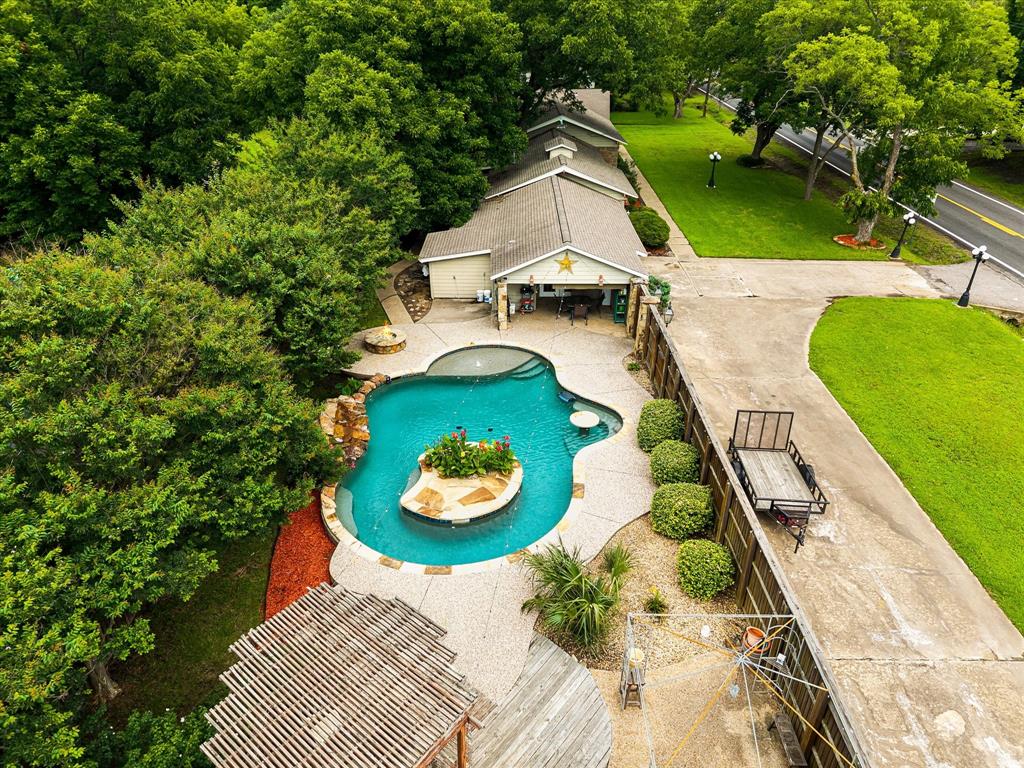 Make every day feel like a vacation in this incredible backyard retreat designed for relaxation and entertaining. The custom pool features a built-in seating area and table, with a unique island design, and plenty of space to enjoy the Texas sunshine. A covered patio and gazebo create the perfect setting for summer gatherings with family and friends. Enjoy time around the firepit cooler fall evenings. Inside, the spacious family room welcomes you with vaulted ceilings and a beautiful fireplace. The kitchen offers plenty of workspace for preparing meals and hosting guests. The private primary suite provides a comfortable escape with dual walk-in closets and a large walk-in shower. Guests and family will appreciate the three full bathrooms, while the convenient half bath located just off the patio is ideal for pool days. A bonus with a wet bar and adds even more space for entertainment. With exceptional indoor and outdoor living areas throughout, this home offers features and amenities that must be seen in person to fully appreciate. Walking distance to all schools and the city park.