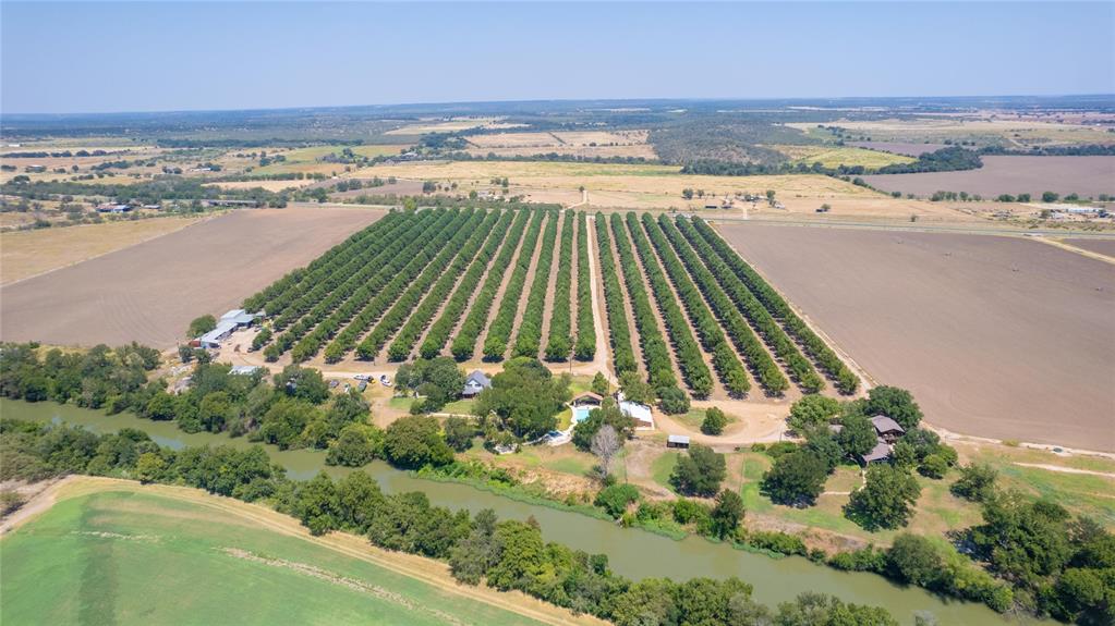 Nestled in the heart of the Pecan Capital of the World, this established family-owned orchard offers a rare opportunity to own a premier agricultural property along the San Saba River. First planted in 1976, the operation has grown to approximately 147± acres and now supports nearly 4,700 producing trees, including popular Pawnee and Texcan varieties.

The orchard is fully irrigated with drip lines supplied by San Saba River water rights—rights that will convey with the sale. Approximately 42± acres sit directly on the river, providing 1,163 feet of scenic frontage.

Improvements include barns and sheds with all necessary equipment for orchard management. Residential features include a spacious 3,047± sq. ft. main home with a pool, pool house, and shop covered parking. A second residence of 2,368± sq. ft. currently serves as an event venue, offering additional income potential.

This is a turnkey investment in one of Texas’ most desirable pecan-producing regions, combining established production, river frontage, and income opportunities.