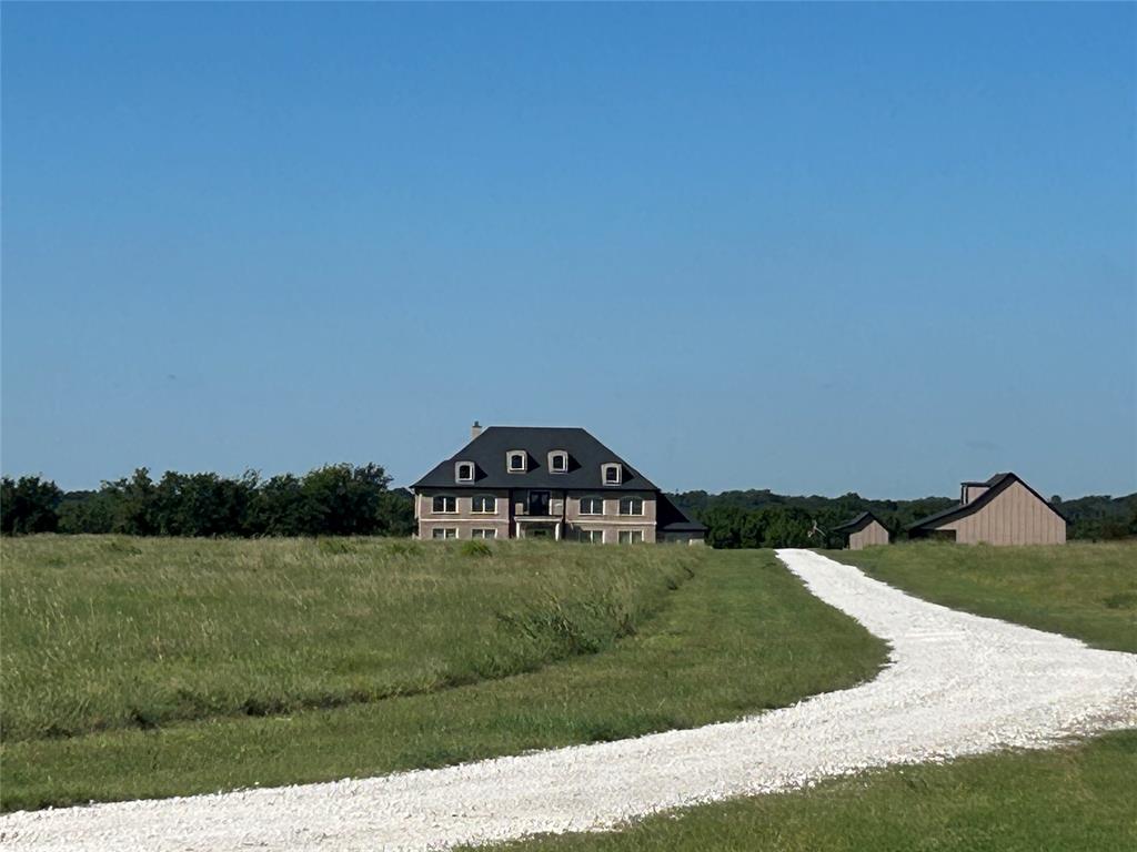 Executive home on 20 acres located in Grandview ISD, easy access to the metroplex and airports.  Hay is cut for ag exemption back of the property includes an incredible view down to the creek with walking paths and sitting area.  Home features a well thought out floor plan, expansive foyer leads to office with built ins and large closet, open kitchen, dining and living area features 21' ceiling, XL utility area with drop zone off garage.  Primary bedroom with floor to ceiling windows with a view of back porch and those beautiful TX sunsets.  Ensuite bathroom, soaking tub, and large walk thru shower with shower heads at each end, double sinks on large vanity and walk in closet with center island drawers.  Upstairs could be used for multigenerational living, 2 bedrooms with ensuite baths, 3rd bedroom and hall bath and don't forget the media living room!  Hall closet downstairs is safe room.  Buyer and buyers agent to verify all measurements.