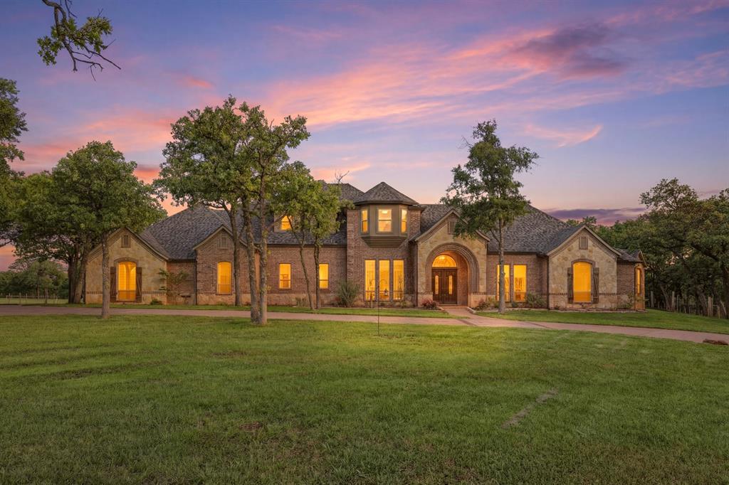 Experience the pinnacle of luxury country living in this extraordinary fully remodeled estate, gracefully situated on nearly 9 breathtaking acres of rolling terrain, towering trees, and panoramic views. Tucked away behind a gated entrance on a secluded private road, this remarkable property offers unmatched privacy, tranquility, and resort-style living designed for both everyday comfort and exceptional entertaining.

Crafted with the equestrian lifestyle in mind, the property features a beautifully appointed 4-stall barn, serene pond, and expansive open acreage enhanced by an agricultural exemption on the additional 7+ acres. A massive 50x40 air-conditioned workshop provides endless possibilities for hobbyists, collectors, entrepreneurs, or additional storage needs.

The outdoor living experience is nothing short of spectacular. A stunning resort-inspired pool with spa and water features creates a true backyard oasis, while the covered patio, outdoor kitchen, and elevated balcony offer the perfect setting for entertaining guests or simply enjoying peaceful Texas sunsets surrounded by nature.

Inside, luxury and warmth blend seamlessly throughout the thoughtfully designed interior. The private primary suite serves as a luxurious retreat complete with its own fireplace, sitting area, and spa-inspired bath. The chef’s kitchen is beautifully equipped with a gas range, farm sink, built-in refrigerator, abundant workspace, and an open flow into the inviting family room—ideal for gathering and entertaining.

Adding even more versatility to the estate is the fully finished game room featuring a stunning wine cellar, full bath, and kitchenette, creating the ultimate entertainment space or private guest retreat.

This rare estate masterfully combines refined luxury, equestrian amenities, functional space, and breathtaking natural beauty to create an unparalleled lifestyle opportunity unlike anything else on the market.