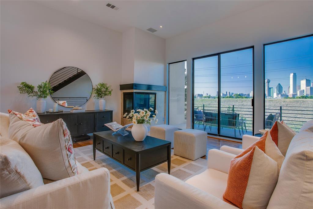 Unobstructed panoramic views of the Downtown Dallas skyline steal the show from every level of this striking three story modern townhome. Tucked inside a secure gated community, this rarely available residence pairs soaring ceilings and walls of glass with three private outdoor spaces that blur the line between laid back comfort and vibrant city living. Daylight pours in. The skyline becomes part of the design. The mood is elevated but effortless. The first level welcomes you with a private guest suite and full bath, generous storage, direct access to the attached two car garage, and a secluded patio ready to enjoy. Upstairs, the main living level is where the home really performs. The spacious living room with gas fireplace opens to a covered balcony with sweeping Downtown views that never get old. The kitchen is built to impress without feeling overdone, featuring custom cabinetry, Sub Zero and Viking appliances, a built in wine fridge, center island, abundant prep space, and a dedicated dining area that naturally gathers people in. The top floor delivers a true retreat. The primary suite captures dramatic skyline views and includes a spa inspired bath and custom walk in closet by California Closets. A dedicated home office with its own private balcony creates a work from home setup that feels anything but routine, while a conveniently located laundry closet keeps life practical. The low maintenance flagstone patio offers flexibility and can easily be converted to artificial turf if you prefer. Freshly painted in May 2026 and the roof was replaced in 2025, this home is truly move-in ready. Just minutes from Downtown, Trinity Groves, and Bishop Arts, and half a block from the DART streetcar, this residence offers rare skyline views from every level with seamless access to the best of Dallas. It feels connected, polished, and just a little bit eclectic. Ready to wake up to the skyline, host under the city lights, and finally call this one home? You know what to do.