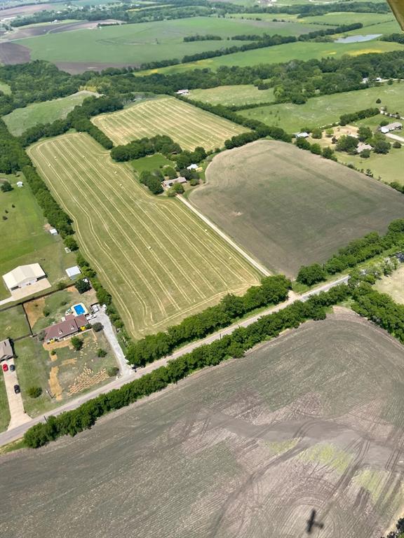 Gorgeous and producing ag acres with so many possibilities given the prime location and outside city limits with no deed restrictions. Commercial, residential, development or  family multi-generational compound!  You name it, its an option!  Huge frontage, flat usable acres are abounding on this plat.  4 minutes to downtown Howe, 10 minutes to 75 creates so many opportunities for your plans and dreams to come to fruition.  There is an inhabitable house that would be perfect for a future office, guest house or live in it while building your dream house!  2 barns and a shed along with a pond create a farming situation as well.  There is a survey with no easements and a drone video available on You tube. Scroll through the pics and find the url link. More pics to come!