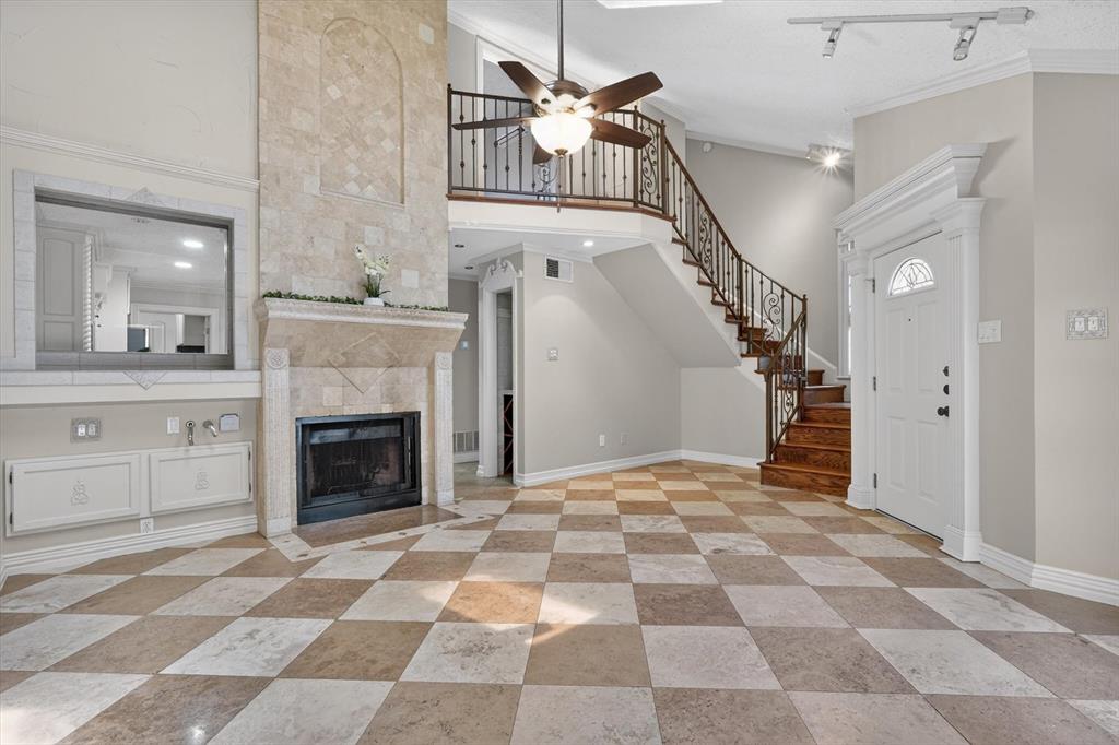 Beautifully updated 3 bedroom, 2 bath half duplex in highly sought-after Coppell ISD, offering a private yard and exceptional storage throughout. This home showcases rich, upscale finishes with a vaulted living room ceiling, skylights that flood the space with natural light, and a dramatic floor-to-ceiling tumbled marble fireplace with a polished granite hearth. A unique built-in plant watering station adds both charm and function. The kitchen features elegant granite countertops, sleek stainless steel appliances, custom cabinetry with decorative appliques, a stylish chandelier, and soft under-cabinet lighting. No carpet anywhere, with refined travertine flooring downstairs and warm genuine wood floors on the stairs and throughout the second level. Sconce lighting in the living room and guest restroom. The flexible floor plan includes a spacious downstairs bedroom and full bath, while upstairs offers two additional bedrooms including a private primary suite with direct bath access. Designer details include crown molding throughout, a handcrafted wrought iron railing, granite window sills, custom tilework, and dimmable lighting. Additional highlights include a luxurious wine closet with marble accents, expansive closet space with built-ins, and beautifully upgraded bathrooms with granite and marble finishes. Major updates include newer AC units upstairs and brand new roof. Ideally located near parks, shopping, major highways, and just minutes from DFW Airport.