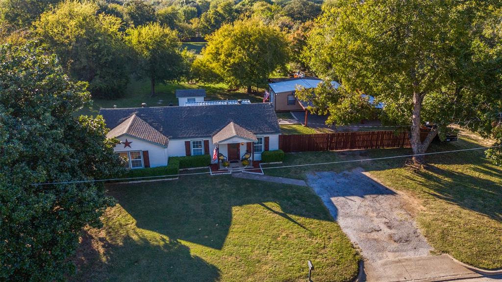 This meticulously maintained residence offers a tranquil county lifestyle in the midst of the metroplex, situated on a spacious 1.272-acre lot. The kitchen was completely renovated in 2019, boasting updated cabinets, granite countertops, LG stainless steel appliances, a gas cooktop, LED under-cabinet lighting, and replaced plumbing featuring PEX lines, drains, and gas lines. Additional updates include new flooring, paint, and a tankless water heater. The bathroom has been refreshed with a tile shower enclosure and a whirlpool tub. A large shop is equipped with a ductless mini-split system, 18,000 BTU Mr. Cool, 100-amp electrical service, and ship-to-shore plugs for an electrical generator. The property is complemented by a metal cedar fence, metal carport, electric gate and UPDATED roof with a Class 4 shingle January of 2026.