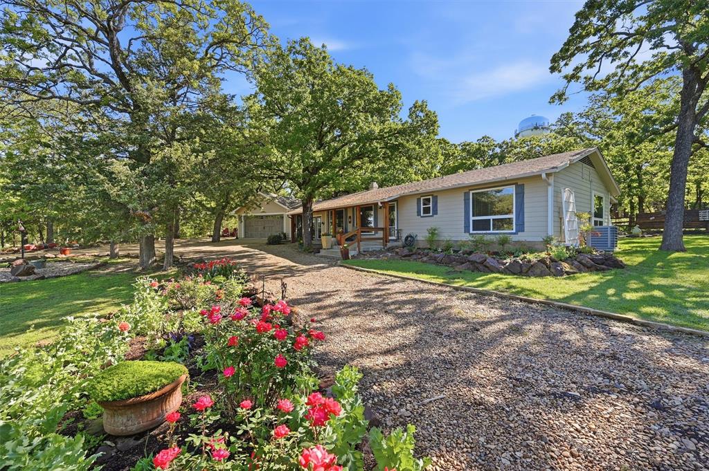 Tucked into a beautifully landscaped corner lot, this storybook cottage feels like a private garden retreat. Surrounded by lush greenery, mature trees, and the soothing sound of a trickling water feature, the setting is nothing short of enchanting. A thoughtfully designed putting green adds a playful touch—perfect for sharpening your short game right at home. The home itself exudes warmth and charm, offering a cozy yet functional layout with 2 bedrooms and 2.1 bathrooms. Inside, an updated kitchen blends modern convenience with cottage character, while the inviting, vaulted living area centers around a fireplace that creates the perfect ambiance for relaxing evenings. An all-weather sunroom invites you to enjoy the beauty of every season, and the expansive bonus room provides endless flexibility—ideal for a second living area, game room, or creative space. Just outside, a darling finished shed offers even more versatility as a home office, studio, or hobby shop. Practicality meets curb appeal with a spacious garage and a large circular driveway, ensuring ample parking for guests. Every inch of this property has been thoughtfully curated, creating a one-of-a-kind haven that feels both peaceful and inspiring.