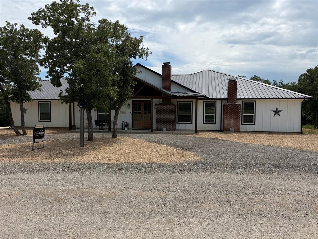 This incredibly well built custom home sits on two acres on a very quiet private road! It's a single story, NO STEPS, with three bedrooms, two full baths and an insulated climate controlled three car garage! The doors are 36 inch for wheelchair access. The laundry is located immediately off the primary bedroom, has a sink, built in cabinets, with pull out drawers, and has plenty of room for a secondary fridge or freezer. The other bedrooms are located in the other wing of the home so everyone can enjoy their quiet time. Both wings can be closed for additional solitude with beautiful barn doors! The primary bedroom has it's own wood burning fireplace. The primary bath has custom cabinets with ALL drawers for ease of access. It also has quartz counters and a huge custom shower! In fact, both baths, the laundry and the kitchen ALL have quartz counters! The kitchen is also amazing including custom cabinets, a HUGE island full of cabinets, a hot water pot filler, tons of counter space for cooking, serving or just entertaining. This is a very open floorplan with another fireplace in the family room. The entire home, including the garage, is foam insulated from the base of the wall to the peak of the roof and is extremely energy efficient! $130 per mth average utilities! Full home generator in case the power goes out! TWO tankless water heaters! Heat, stove top and water heaters are all propane! Even though it is in the country it has city sewer, water, and electric. There is an extremely large covered patio - the perfect place to relax, or cookout, or entertain! And if you have friends with an RV, there is an RV with 50amp service and water is available! Horses are also allowed on the property. This home is beautiful, very new, and move in ready! Make an appointment to see it today!