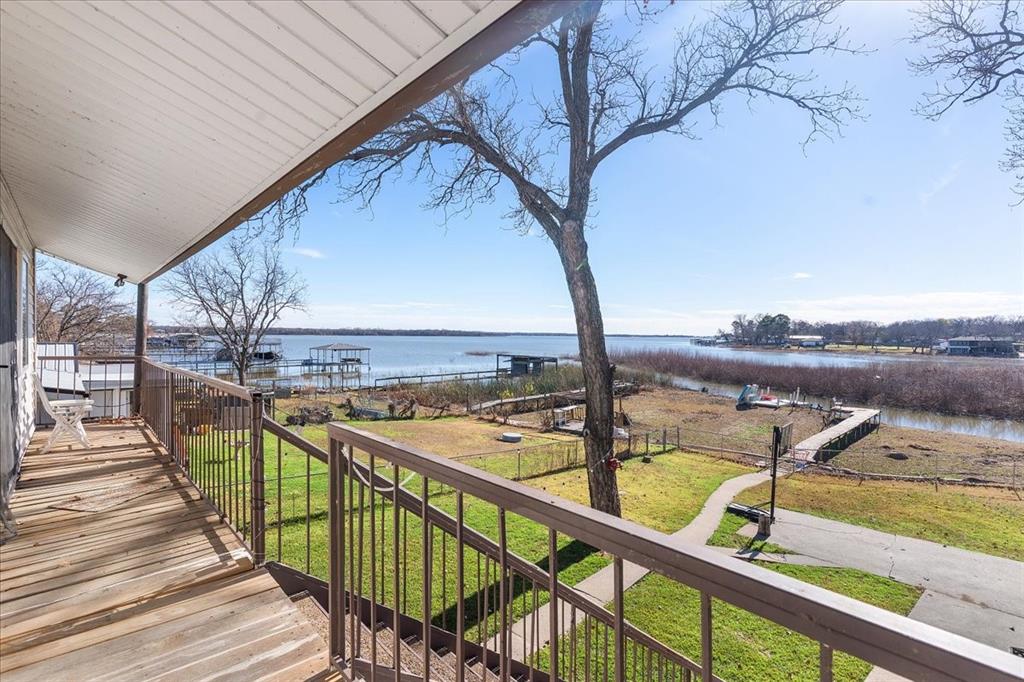 Located just minutes from TX-199 in Azle, this thoughtfully updated home offers a true lake lifestyle with direct access to Eagle Mountain Lake and a private dock, perfect for boating, fishing, or relaxing by the water. The fenced backyard features multiple outdoor living spaces designed for both entertaining and everyday enjoyment, including a covered upper porch off the secondary bedrooms and a lower-level patio connected by stairs. A one-car carport at the front of the home provides convenient parking. Inside, the open-concept layout is bright and inviting, anchored by a fully updated kitchen with a center island, breakfast bar, and an oversized utility room that also functions as a pantry with additional shelving. The kitchen flows seamlessly into the dining and living areas, where recessed lighting and large windows bring in abundant natural light. The main-level primary suite offers privacy and comfort with an upgraded vanity, walk-in shower, walk-in closet, and a nearby half bath for guests. Upstairs, two spacious secondary bedrooms each include their own full bathroom. One bedroom is oversized, offering flexibility as a guest suite, game room, or additional living space. With no HOA, this property provides the freedom to enjoy and personalize your space. Conveniently located near public boat ramps and Shady Grove Park, which offers a lakefront beach, fishing pier, playground, and walking trails, and just minutes from shopping, dining, and everyday essentials.

Incredible investment opportunity! This property is currently operating as an Airbnb with Superhost status. Sold turnkey - furniture, dishes, and household essentials included (seller's personal items excluded). Step in and start earning immediately with no setup required.
... and all of this priced under appraisal!

Discounted rate options and no lender fee future refinancing may be available for qualified buyers of this home. Sellers covering closing costs!