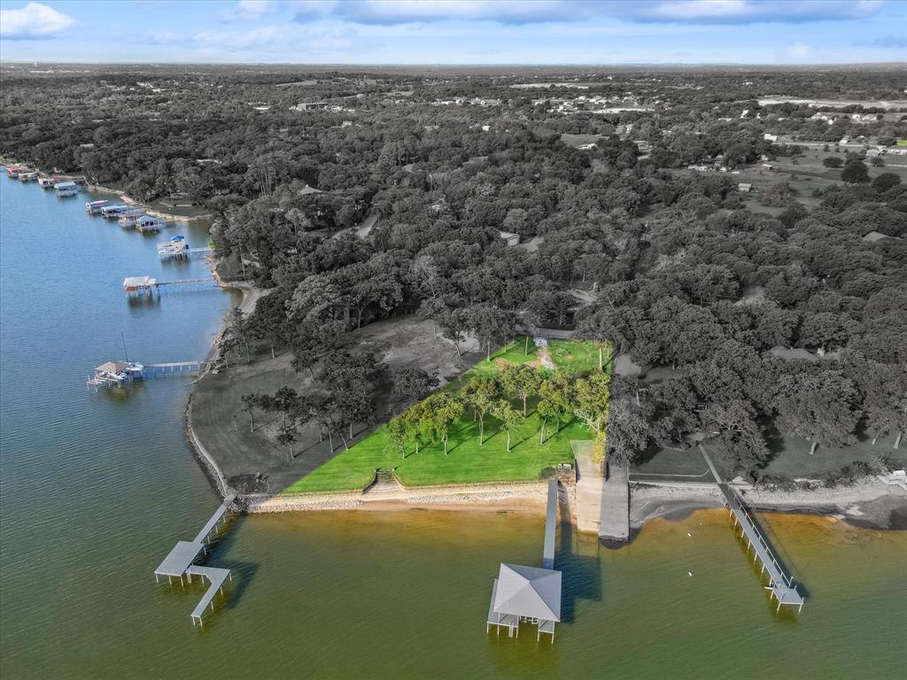 Welcome to this exceptional lakefront lot on Eagle Mountain Lake, featuring 205 feet of prime shoreline. The property comes fully equipped with water and electricity onsite, and a brand-new boat dock for easy access to the water. A convenient boat ramp is also included, making it simple to launch your boat or watercraft right from your own property. The 8-foot stone sea wall is in excellent condition, offering both durability and a beautiful, timeless look.

Take in unobstructed views of the mid and upper portions of the lake, perfect for relaxing or entertaining guests. Located on the main lake channel, you’ll enjoy easy access to the water while maintaining a peaceful and private setting. A newly installed irrigation system ensures your landscaping remains vibrant and well-maintained.

Ready to build, this lot offers the flexibility of a build-to-suit option, with construction plans, grading plans, and aerobic septic plans complete and available to help bring your vision to life. Plus, with the property located outside city limits, there are no HOA restrictions, giving you the freedom and privacy you desire.

This is your chance to own a piece of paradise on Eagle Mountain Lake—don’t miss out! Lots 7 & 8 can be purchased together - reach out for pricing.
