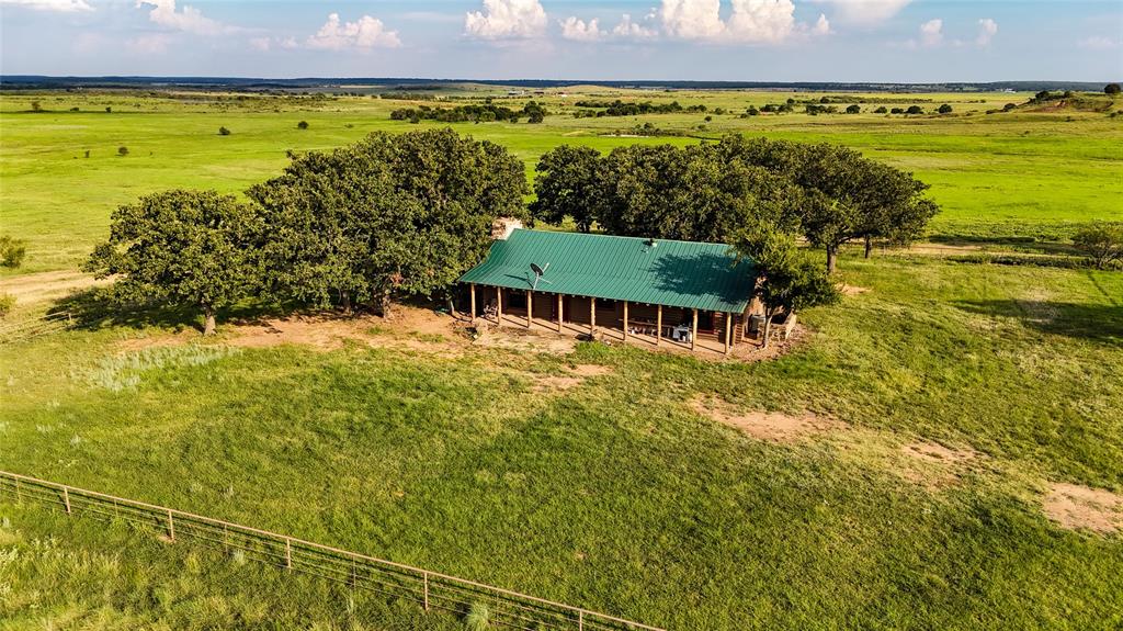 Located just 19 miles west of Bowie and a few miles south of Vashti, Promontory Ranch is a true North Texas showplace offering the perfect blend of beauty, productivity, and recreation. Spanning 1,137± rolling acres, this ranch captures everything that makes Clay County ranch country so special; wide-open vistas, mature hardwoods, and abundant wildlife. The landscape rolls gently with roughly 110 feet of elevation change, creating a scenic backdrop from nearly every point on the ranch. The land is a healthy mix of 70% pasture and 30% hardwood cover, dotted with majestic oaks and excellent wildlife habitat. Fourteen ponds are scattered across the ranch, providing reliable water for both livestock and wildlife. The property is fully fenced and cross fenced for cattle, with a good blend of coastal and native grasses that make it as functional as it is beautiful. The ranch is well suited for a strong cattle operation and comes equipped with working pens and plenty of grazing capacity. At its heart sits a charming 1,200± sq. ft. log cabin featuring 2 bedrooms and 2 baths, offering a comfortable retreat after a long day on the ranch. Nearby, a 40x50 shop with electric service provides ample space for equipment storage or future expansion. The ranch operates on a private water well, septic system, and electric utilities. Promontory Ranch is a hunter’s paradise. The mix of pasture and wooded draws supports whitetail deer, turkey, hogs, dove, and more. With year around water sources, natural cover, and limited pressure, the property is perfectly set up for exceptional hunting or wildlife management. With county maintained road frontage on both the east and west sides, the ranch is easily accessible yet remarkably private. Its dual frontage also offers flexibility for future division or investment potential, making it equally attractive to ranchers, investors, and recreational buyers seeking a legacy property.
