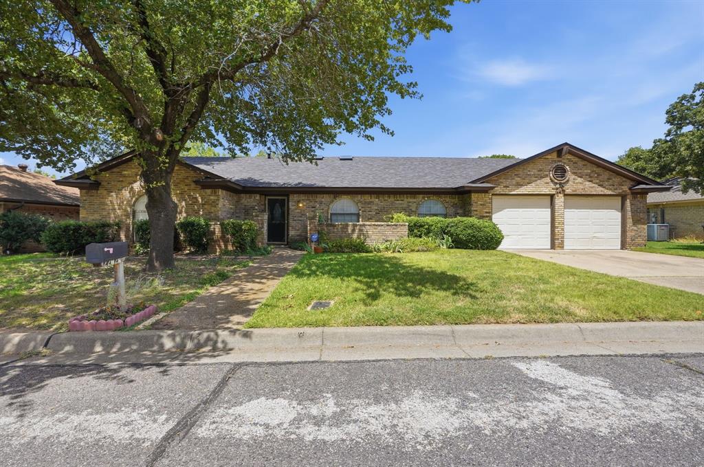 Feeding the award-winning Arlington ISD, this lovely single-story brick home is perfectly located on a quiet lot in Woodcanyon Addition. The functional  floor plan presents four bedrooms, two full and one half bathrooms, a formal living room and dining area, a spacious family room, a gourmet kitchen with an adjacent breakfast area, and a two-car garage with a dedicated utility area. Quality abounds with gracious windows, luxury vinyl plank flooring, a traditional stone-hearth gas fireplace and a vaulted ceiling with two sky lights in the family room. The serene primary suite offers direct egress to backyard, a walk-in closet, and a spa-inspired bathroom retreat. Surrounded with an eight foot fence, this backyard presents plenty of room for play and a storage shed. Additional improvements include an upgraded oven, microwave, and a disposal - all replaced in 2026. The kitchen cooktop was replaced in 2025. A new fence installed and roof and gutters upgraded in 2025.