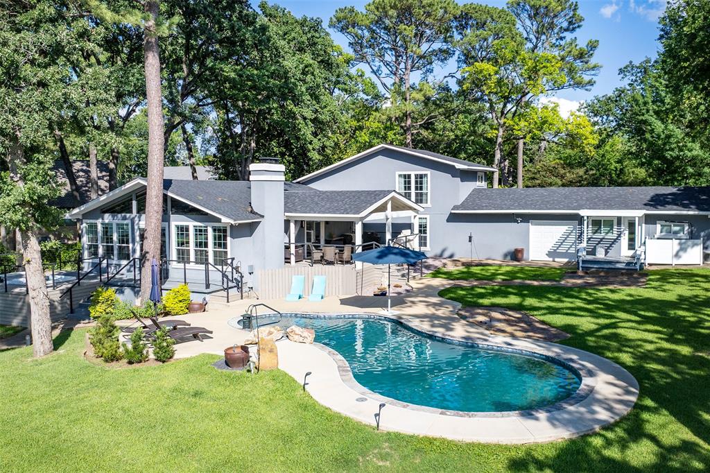 Beautifully renovated waterfront home on Cedar Creek Lake, just an hour southeast of Dallas. Featuring 4 bedrooms and 4 full baths in 2733sf, this thoughtfully designed retreat includes a 502sf private guest suite separated from the main house by the attached 2-car garage. Perfect for weekend guests who need more privacy or multi-generational full-time lake living.  Soaring vaulted ceilings with dramatic exposed beams, walls of windows, and an open-concept floor plan create an inviting atmosphere for entertaining. The chef's kitchen boasts an oversized island and abundant storage. Outdoors, enjoy a resort-style pool, spacious gathering areas, and a private boathouse with boat and Sea-Doo lifts. Whether as a weekend getaway or full-time residence, this home offers the best of relaxed Texas lake living.  Upgrades include HVAC and roof in 2023, all new cabinets, added PWC lifts to boathouse, tankless water heater, added hot tub, spray foam insulation in attic, new fixtures throughout. Move-in ready to enjoy!