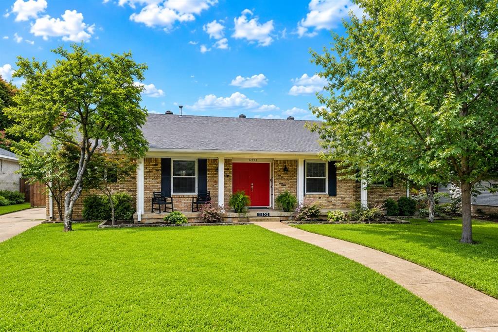 Nestled beneath a canopy of mature trees in the heart of Lochwood, one of East Dallas’ most established and sought-after neighborhoods, this beautifully updated home offers the perfect combination of timeless character and modern convenience. Thoughtfully updated throughout, the flexible floor plan provides multiple living and dining spaces that easily adapt to everyday living, entertaining, working from home, or hosting gatherings. The remodeled kitchen serves as the centerpiece of the home, featuring granite countertops, extensive cabinetry, stainless steel appliances, a gas range, and generous prep and storage space. The kitchen opens seamlessly to the spacious living room, where dramatic wood beams and a fireplace create a warm and inviting space. Large windows throughout the home fill the interiors with natural light and showcase views of the beautifully landscaped yard.
The private primary suite offers a relaxing retreat with a stunning remodeled bath featuring dual vanities, marble finishes, and elegant details. Additional bathrooms have also been updated with stylish finishes and thoughtful design. Recent improvements include newer windows, a roof replaced in 2019, updated lighting, and a beautifully redesigned laundry room with abundant storage. Outside, the impressive curb appeal continues with lush landscaping, mature shade trees, and an electric driveway gate that provides added privacy and convenience. The backyard offers ample space for outdoor entertaining, gardening, pets, or simply enjoying the peaceful surroundings. Ideally located just minutes from White Rock Lake, scenic trails, neighborhood parks, shopping, dining, and all that East Dallas has to offer, this move-in ready Lochwood home combines thoughtful updates, functional living spaces, and the charm that has made this neighborhood a favorite for generations.