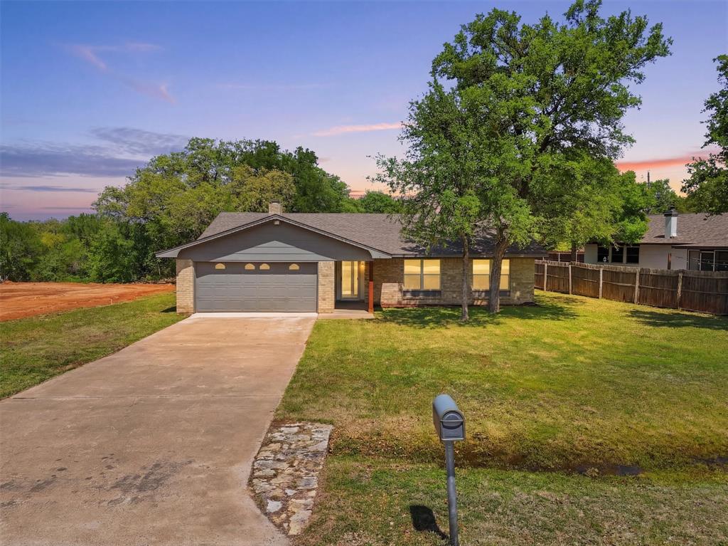 Welcome to DeCordova Bend Estates, where gated golf course living meets everyday comfort. This 3 bedroom, 2 bathroom home offers 1,698 sq ft with a layout that feels open, bright, and easy to live in.

Step inside to a spacious living area featuring vaulted ceilings with exposed beams, LVP flooring throughout, and a wood burning fireplace that anchors the space with warmth and character. Natural light fills the room, creating an inviting atmosphere that flows seamlessly into the dining area and kitchen.

The kitchen is fresh and functional with painted cabinetry, updated countertops, stainless steel appliances, and a window over the sink that brings in great natural light. Just off the main living space, the bedrooms are well sized with a comfortable primary suite and a practical layout for everyday living.

Outside, you will find a large yard with mature trees, a 2 car garage, and plenty of space to enjoy outdoor living.

Located inside DeCordova Bend Estates, this home comes with access to a long list of amenities including golf courses, a marina, clubhouse, pickleball courts, volleyball courts, basketball courts, and gated security. Whether you are looking for full time living or a weekend retreat near the lake, this home offers both lifestyle and value in one of Granbury’s most sought after communities.
