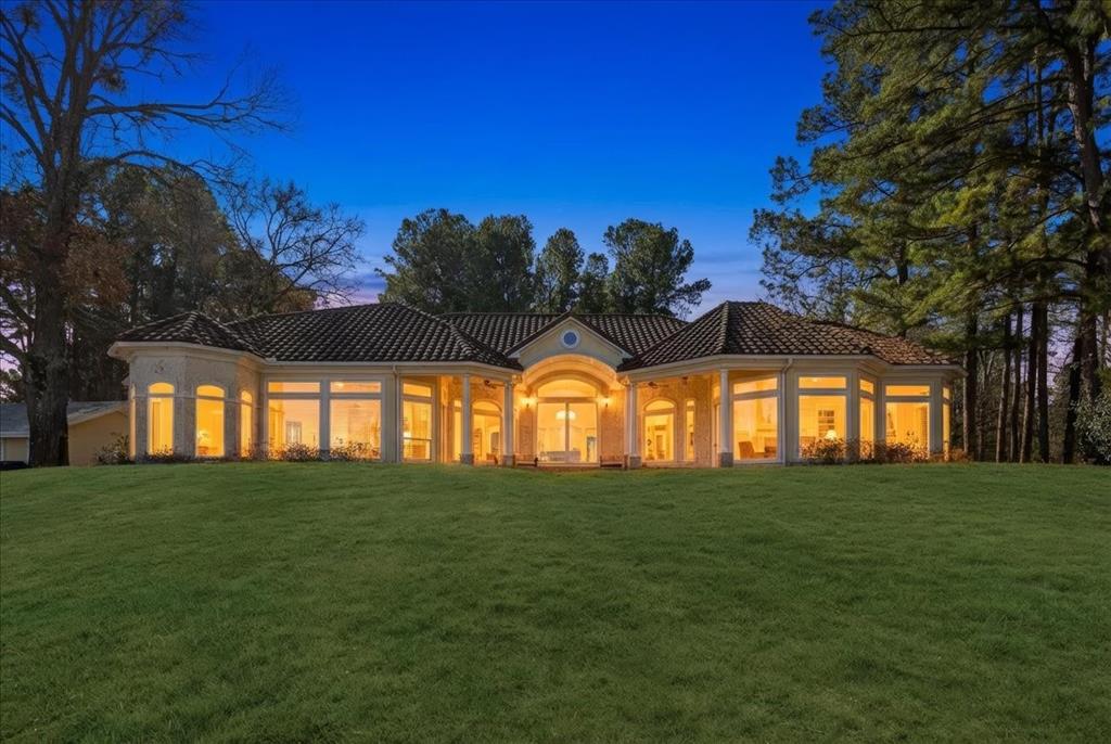 Discover the epitome of luxury living in this stunning Mediterranean style estate, situated on over 10 acres of pristine land and 700' of shoreline with breathtaking sunset views over Lake Palestine. You'll enter this exclusive property through a private gate and traverse a picturesque three-quarter-mile drive lined with majestic tall pine trees, setting the stage for a truly exceptional retreat. This home features 3 bedrooms and 3 baths, a designated office w built-ins, and a versatile craft and or bonus room perfect for creative endeavors. The covered back patio invites you to savor the tranquility of your environment. Gourmet moments await in the chef’s kitchen, boasting granite countertops, a sizeable island with a cozy sitting area, and a stunning crushed seashell chandelier that adds a touch of coastal charm. A butler's walk-in pantry provides additional storage and functionality, making entertaining effortless. Enjoy the inviting seating area designed for entertaining while overlooking the mesmerizing lake views. But the allure doesn’t end there. This estate also includes an 800-square-foot guest home, ideal for hosting family and friends, and a two-stall boathouse featuring a jet ski lift and pergola-covered seating area, perfect for sunset gatherings. With a pristine private beach, a swim platform, and an outdoor kitchen, your summer days will be filled with relaxation and enjoyment.
A dedicated shop offers ample space for RV or boat storage, while an outdoor hot tub and inviting seating area provide the ultimate outdoor retreat. Embrace the freedom of no restrictions and the luxury of this unparalleled property, where every detail has been thoughtfully designed for the ultimate lifestyle. This is more than a home; it's a secluded sanctuary where luxury meets nature, inviting you to live your dream.