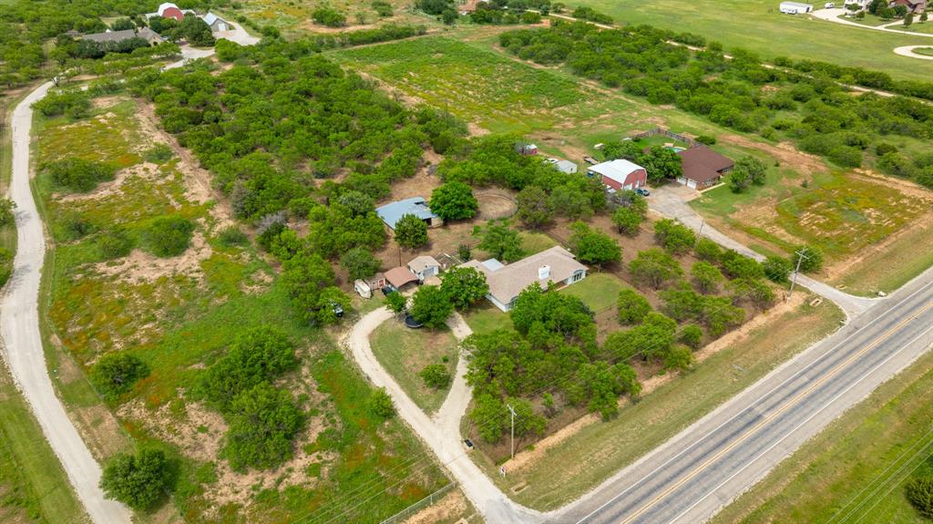 Agent Owner. Set on 4.7 acres, this 3 bed, 2 bath property offers the perfect blend of modern updates and wide open space. Inside, you are welcomed by an enormous living room featuring stunning wood plank vaulted ceilings with accent beams and a striking stone fireplace, an ideal space for gathering or relaxing. The kitchen has a sleek, modern feel with natural stone countertops, stainless steel appliances, and brushed gold fixtures. A cozy eat in breakfast area includes a charming window seat and breakfast bar, making it the perfect spot to start your day. The primary suite is a true retreat, offering plenty of room for a king size bed plus additional space for a sitting area, home office, or workout setup. The ensuite bath features a double vanity, walk in shower, soaking tub, and a spacious closet. A sunroom provides a great place to entertain or simply unwind while taking in views of the property. Outside, the acreage is ready for your animals with a barn with stalls, round pen, and ample space for livestock. This property combines comfort, style, and functionality, perfect for enjoying country living without sacrificing modern touches.