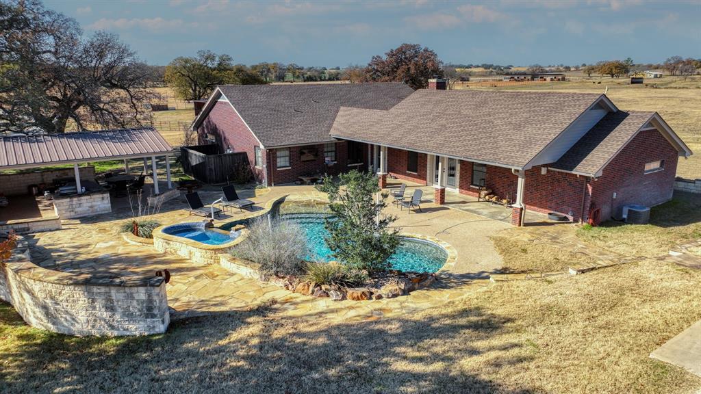 This unique 24.6+- acre property seamlessly blends custom living with top-tier equestrian amenities. The 2,900+- s ft home features four bedrooms, three bathrooms, and two spacious living areas, enhanced by custom oak doors and striking custom chandeliers throughout. Outdoor living is elevated with a pool, waterfall hot tub, and a covered rock outdoor cooking area, perfect for entertaining. An in-ground propane tank runs the grill, hot tub, and pool.
Designed with horse owners in mind, the property includes four cross-fenced pastures, three ponds, three large turnout shelters, and two pipe water lots. The equestrian facilities are anchored by a 150 ft x 300 ft pipe arena with pens, a Priefert solar chute, adjustable head box, and a four horse programmable free flow panel walker. The 25 ft by 30 ft insulated, finished, and heated shop features shed-row style stalls (three total) and one pen, offering both functionality and convenience.
A rare opportunity to own a well appointed home with thoughtfully designed facilities, ideal for seeking comfort, privacy, and performance in one impressive property.