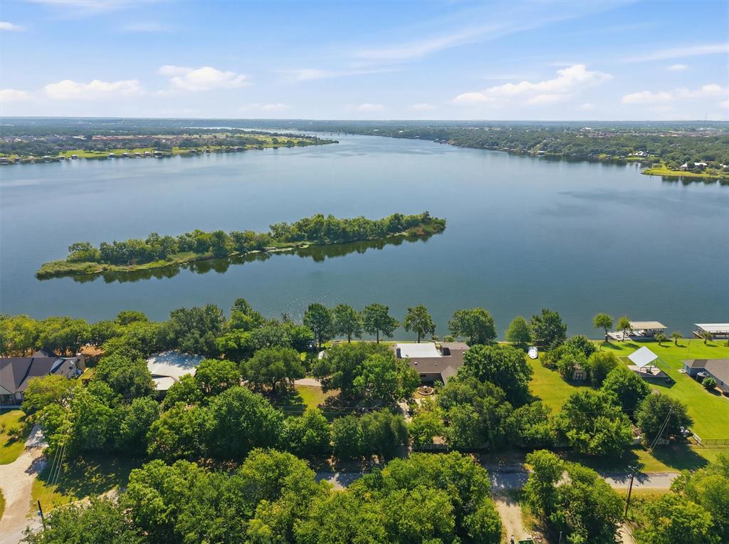 Welcome to your Lake Granbury retreat, enjoy the sunrise at this one of a kind property with almost 400' of water frontage, 1.57 acres lot (5 gated lots) featuring a rock retaining wall across the entire waterfront, a two story covered dock, a green house, and plenty of extra space for expansion or storage.  Garage spaces 15x15      27x23    23x9   10x29
The property has been thoughtfully renovated, maintaining its charm, while also offering a move-in-ready experience.
Step outside to enjoy mature trees, outdoor living spaces, and direct access to Lake Granbury for boating, fishing, kayaking, or simply relaxing by the water. A spacious 1,830sqft air conditioned workshop provides endless possibilities for hobbies, entertainment or projects, while ample parking easily accommodates guests, recreational vehicles, or boats.
Tucked away on the quiet cul-de-sac of Sunrise Bay, yet only minutes from Granbury's charming Historic Square.
This home must be seen in person to be appreciate it.
It would make a amazing forever home, VRBO or Airbnb. No flood insurance necessary. No water bill (shared well) Outside City limits
Schedule a viewing time today!