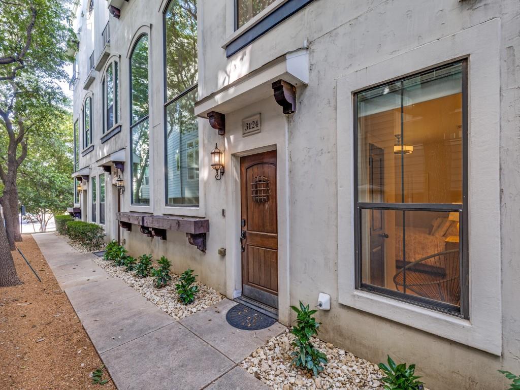 Set beside the tree-lined edge of Exall Park, this three-story townhome at 3124 Carmel St, Dallas unfolds as a light-filled urban retreat with sweeping rooftop views of the Dallas skyline. Thoughtfully arranged across three levels, the home balances openness with privacy, creating spaces equally suited to entertaining and quiet retreat.

Entry is marked by travertine flooring, leading to a first-floor guest suite with a full bath and a built-in workstation, ideal for guests or a private office. Above, the second floor is dedicated to living, where tall ceilings and expansive windows draw in natural light throughout the day. Wood floors run underfoot, connecting a generously proportioned living room with a separate dining area and a well-appointed kitchen. A brick feature wall introduces a subtle loft-like character, complemented by designer lighting and ample workspace.

The third floor is given over to the primary suite, a spacious and calm setting with a sitting area and an oversized walk-in closet. The bath is composed with intention, offering dual vanities, a soaking tub, separate shower, and a private water closet. Laundry is positioned on this level for ease and efficiency.

Above it all, a rooftop deck captures uninterrupted skyline views, an open-air extension of the home suited to both quiet mornings and evening gatherings.

A two-car garage provides secure parking and storage. 

Positioned in the heart of the city, the home enjoys immediate access to Exall Park’s green space and recreation center, along with nearby dining and entertainment in Deep Ellum, Uptown, and Lower Greenville. Downtown and Lakewood are moments away, with White Rock Lake offering miles of trails and waterfront leisure just to the east.