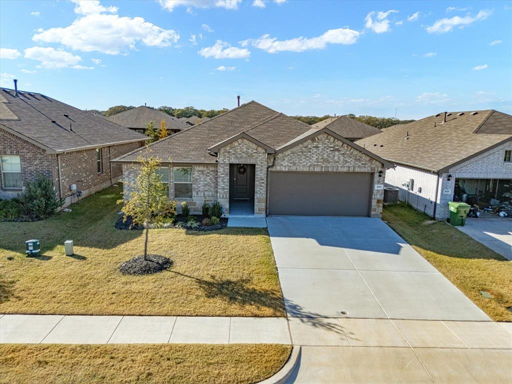 This beautiful 4-bedroom, 2-bathroom brick-and-stone home sits in a quiet, family-oriented neighborhood and offers the perfect blend of comfort, style, and everyday convenience. Step inside to an open floor plan designed for easy living and effortless entertaining. The spacious kitchen is a dream with granite countertops, a massive island, gas range, stainless steel appliances, and plenty of cabinetry for all your cooking needs. A dedicated laundry room sits just off the kitchen and accommodates a full-size washer and dryer. The dining and living areas flow together, creating a warm, inviting space for meals, movie nights, or hosting family and friends. Throughout the home you’ll find a smart mix of tile, LVP, and carpet, offering durability where you need it and comfort where you want it. The primary suite and three additional bedrooms provide flexibility for guests, kids, a home office, or whatever your lifestyle calls for. Step outside to enjoy a covered back porch, perfect for morning coffee or weekend grilling. The yard is nicely landscaped and supported by gutters and a full sprinkler system for easy maintenance. A two-car garage rounds out the package. If you’re looking for space, style, and a peaceful neighborhood feel — this Springtown beauty checks all the boxes. Don’t miss it!