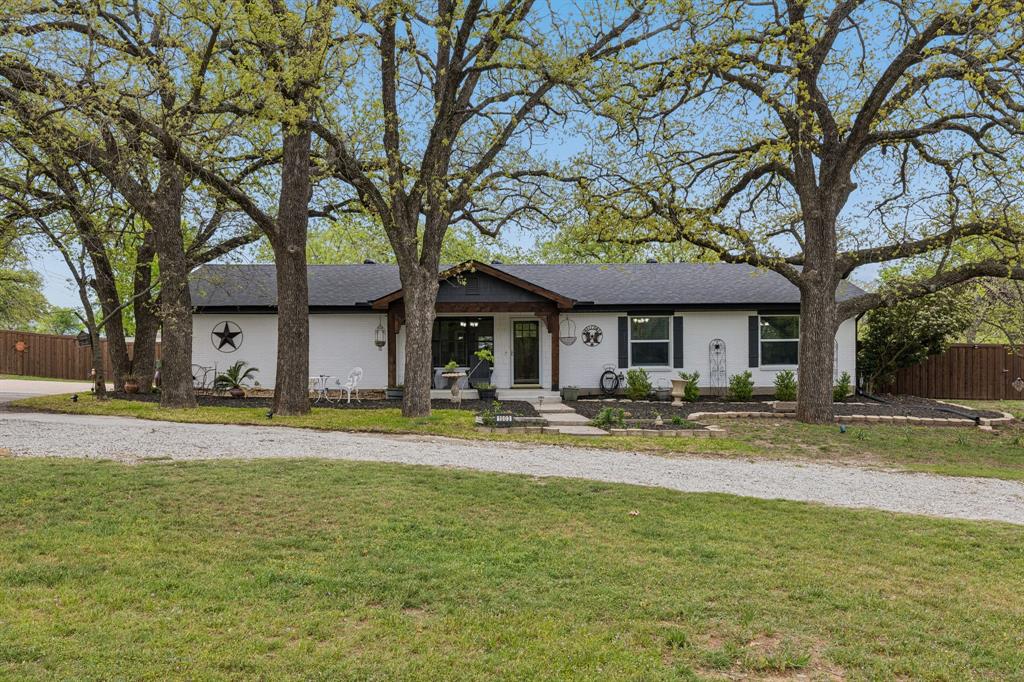 Welcome to your dream home on nearly an acre in the coveted Hudson Heights subdivision — no HOA, no compromise. This stunning 3-bedroom, 2-bath ranch house was meticulously remodeled top to bottom in 2021–2022, blending modern elegance with timeless charm. From the moment you arrive, the striking cedar accents on the exterior, inviting front porch, mature shade-giving oak trees, and sweeping U-shaped gravel driveway deliver undeniable curb appeal. Step inside to find luxury vinyl plank flooring flowing through the living areas, kitchen, and den, plush new carpet in the bedrooms, and sophisticated crown molding and 5-inch base molding throughout. The show-stopping updated kitchen features solid wood cabinets, gorgeous granite countertops, a gas cooktop, and a double oven — oversized pantry, pull-out shelves, and a spacious laundry room with a built-in coffee bar elevate daily living. The expansive living area opens through French glass doors into a serene den — the perfect flex space for a home office or private retreat. From the den, Pella glass doors lead out onto the gorgeous composite deck on the rear of the home, ideal for entertaining or unwinding. The spa-inspired master bath boasts a beautifully tiled shower with a glass door, while the guest bath features an oversized soaking tub with glass shower doors. Every bedroom includes custom closet systems, and all bathrooms were completely refreshed with new cabinets and countertops. Out back, the fully fenced yard is a gardener's paradise featuring a greenhouse with brick floors, raised garden beds, two peach trees, and plenty of room to roam. A large storage shed with electricity and a garage door handles all your equipment, and a whole-house water filtration and salt system adds peace of mind. Located in sought-after Weatherford ISD and just minutes from I-20 — this is Parker County living at its finest.