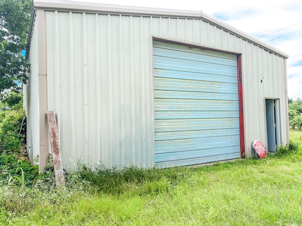 Rare opportunity to own a versatile 0.45-acre property located outside city limits with county road frontage. The property features a 40' x 30' metal workshop on a concrete slab with electricity in place, making it ideal for a variety of residential, recreational, storage, or hobby uses. The shop includes an 11-foot roll-up door for convenient access to vehicles, equipment, trailers, or workspace needs. The property is fully fenced and gated, offering security and privacy. Enjoy the benefits of a rural setting with easy access from a county-maintained road and fewer restrictions typically associated with city properties. No water meter but Point Enterprise services the area.  Buyer to verify all information, utilities, and permitted uses.