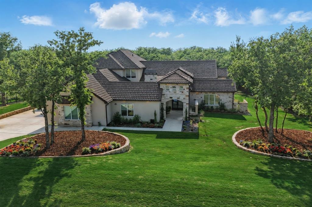 Luxury truly lives in the details of this exceptional custom home, tucked at the back of an exclusive gated community in Flower Mound and zoned to highly sought-after Argyle ISD. Situated on a one-acre lot, this estate was designed for everyday comfort and effortless entertaining. The open-concept kitchen and living area showcase soaring beamed ceilings and top-tier appliances including a Sub-Zero refrigerator, Wolf range, double ovens, and refrigerated drawers. A fully equipped prep kitchen with a second dishwasher, wine and a full size beverage and wine fridge, ice maker, and walk-in pantry keeps hosting seamless and organized. The primary suite feels like a private retreat with two walk-in closets, a personal gym with Tonal system, sauna, coffee bar with mini fridge, spa-inspired shower, and even an outdoor shower! Most of the living space is thoughtfully located on the first floor, including four spacious ensuite bedrooms with walk-in closets, a private office with its own bath that could serve as a sixth bedroom, and a den with built-in desks. Upstairs offers flexibility with a game room (complete with reading nook and murphy bed), kitchenette, full bath, and guest suite ideal for entertaining or multigenerational living. Outdoor spaces were equally prioritized with a front courtyard featuring a fireplace, dining space and water feature, then the backyard oasis complete with pool, spa, firepit, outdoor fireplace, and full outdoor kitchen with built-in grill and fridge. Additional highlights include a 4-car garage with HVAC, dog wash station and two EV chargers, whole-home Halo water filtration, smart home features, integrated SONOS system with TVs included, level 4 tile roof, two whole-home generators, and a pool with in-floor cleaning system and hard cover. Experience elevated living at its finest. Visit www.5017Castellano.com for photos, floor plan, and 3D tour.