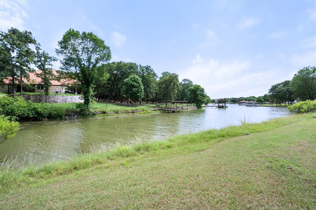 Rare Find at Richland Chambers Lake!!! Here is your opportunity to own a home with 10 Acres on Richland Chambers Lake in Mildred ISD! With NO HOA and no known restrictions, this property offers endless possibilities and freedom to create the lakefront lifestyle you’ve been dreaming of. This property has incredible potential to become your dream lake retreat, full-time residence, or investment opportunity. With 10 Acres and no HOA you have the ability to bring your horses or FFA animals. Where the home is placed on the acreage, there is even potential to build another home closer to the water! This 3-bedroom, 2-bath home is ready for your vision and personal touch. Inside the brick home, you’ll find a spacious living room with a cozy fireplace, perfect for gathering with family and friends. The primary suite features an ensuite bathroom, while two additional bedrooms share a convenient hall bath. A large utility-laundry room with ample cabinet storage adds extra functionality and convenience. Step outside and take in the beauty of countryside living from the covered front and back porches, ideal for entertaining, relaxing, or simply soaking in the peaceful surroundings. Start your mornings with coffee and breathtaking sunrises, then wind down in the evenings with unforgettable Texas sunsets over Richland Chambers Lake. Properties offering this much land, waterfront access, and freedom are hard to find—don’t miss your chance to make this one your own!