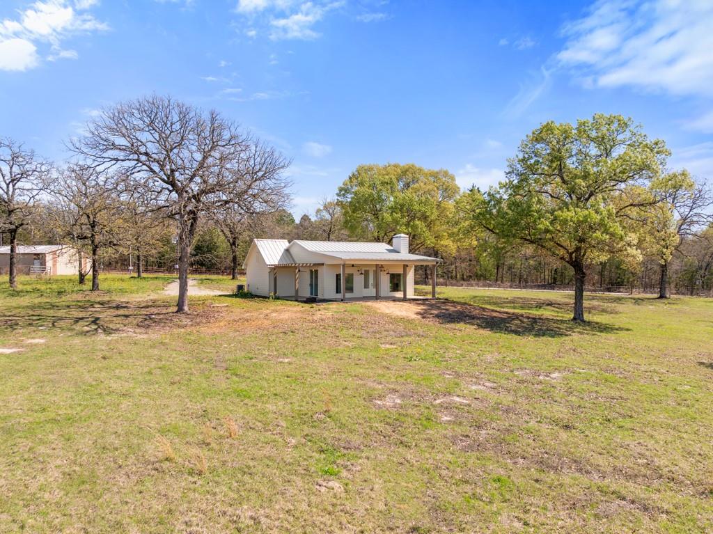 Set on nearly 11 scenic acres, this newly constructed modern farmhouse blends peaceful country living with fresh, elevated design. Surrounded by mature trees and open pastureland, the property features a picturesque pond stocked with bass and brim, wide-open skies, and unlimited possibilities. This is what East Texas dreams are made of. In addition to the beautiful new modern farmhouse that has never been lived in, the property features a large shop with heated and cooled furnished apartment. Several other building sites, storage buildings and a loafing shed. Bee-keeping equipment can also convey as well as 2 adorable donkeys. There is a tenant in an additional small cabin on one corner of the property.