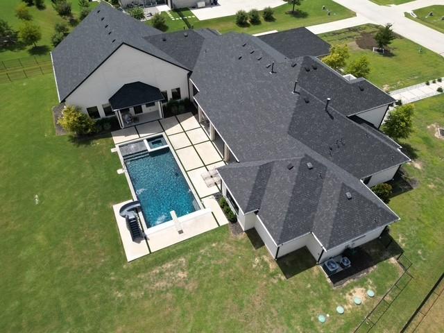 Tucked away at the end of a serene gated cul-de-sac, this extraordinary Dave Williams custom home is more than just a residence—it’s a private retreat designed for living, entertaining, and making memories. Sitting on 1.53 wooded acres, this home invites you in with the quiet charm of mature trees and the promise of something special just beyond the front door.

From the moment you step inside, you’re greeted with an airy open floor plan that feels both sophisticated and inviting. Imagine family gatherings around the striking fireplace in the living room, or slow mornings in the chef’s kitchen—complete with quartz countertops, commercial-grade appliances, double convection ovens, an oversized island, and a walk-in pantry that hides a built-in coffee bar (hello, latte mornings!).

The private primary suite is a true sanctuary, with a cozy sitting area, spa-like bath, dry sauna, and a custom closet that feels more like a boutique. Each of the five bedrooms has its own ensuite bath and walk-in closet—offering comfort and privacy for everyone.

But the showstopper? A private indoor half-court basketball gym—because why not practice your jump shot whenever you want?

And when the sun’s out, head to the backyard where two covered patios overlook a sparkling pool with slide and spa. The fenced yard backs to a peaceful greenbelt, giving you space, privacy, and that “forever home” feeling.

Located in sought-after Celina ISD with easy access to local dining, shops, and community favorites, this home is the perfect blend of quiet luxury and vibrant living.