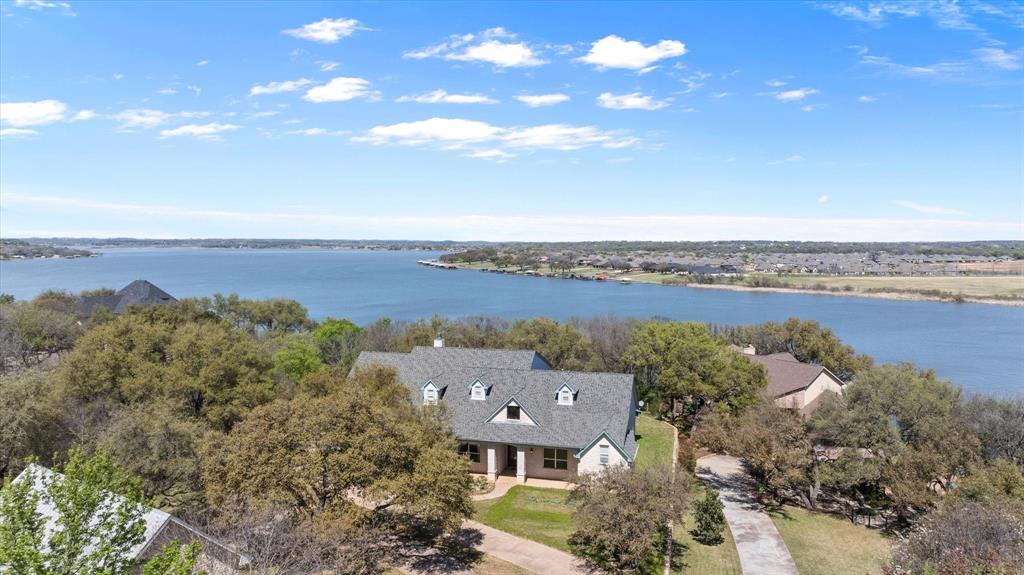 MAINBODY waterfront on Lake Granbury.  Wow check this 5 bedroom, 5 bath with oversize garage in Summerlin area of Granbury.  Just minutes north of the Historic Granbury square area.   Just off Loop 567 makes this home easy access from Weatherford, Metroplex or Granbury.  Home was updated and had Kingdom builders do a lot of work inside in 2025.   The home sits up on the bluff overlooking Lake Granbury with walkway down to a covered boat dock, with a boat lift.  Just minutes across the lake from Hunter park and just west of Hwy 51 bridge this makes the lake access easy to put boats in or jet skis for a family gathering.   Home has 2 sitting areas,  living areas, and a huge back patio, porch and upper balcony for sitting, viewing and enjoying the lake views and adventures.   The kitchen has a built in refrigerator, chefs kitchen with large island and cook top.   This home is a great family gathering spot to enjoy that large family.  4 bedrooms upstairs, with a bonus room that is storage now, but if needed could be added space with a little work.  Home has a 5 car garage with a side entry.   2 fireplaces.   Summer is almost here, time to enjoy this amazing home and make it yours.