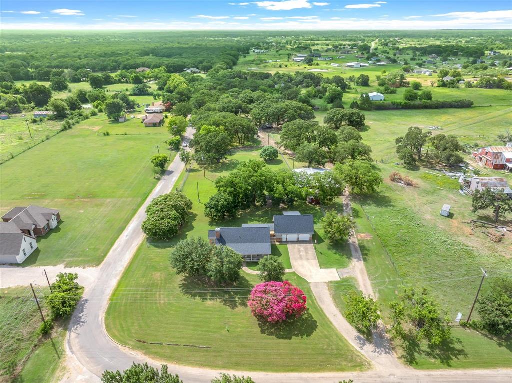 Welcome to this beautifully updated brick home in the charming community of Scurry, just approximately 35 miles from Dallas for an easy commute. This spacious 4-bedroom, 3-bath home offers a versatile floor plan with three bedrooms in the main house and a private, oversized fourth bedroom or bonus room above the attached two-car garage—ideal for guests, a home office, or game room. The inviting living room features a stunning floor-to-ceiling stone fireplace with a raised hearth, custom built-in cabinetry, and plenty of space for gathering with family and friends. Recent updates include fresh interior & exterior paint, new carpet, and numerous additional improvements, making this home move-in ready. Situated on an oversized 1.7-acre lot, the property offers room to roam with plenty of space for children, pets, gardening, or simply enjoying the peaceful small-town lifestyle. Relax under the attractive backyard pergola or take advantage of the impressive 3,000-square-foot workshop—perfect for a business, hobbyist, craftsman, or additional storage.

Located in the highly regarded Scurry community, known for its excellent schools and welcoming atmosphere, this property combines country living with convenient access to Dallas. Don't miss this exceptional opportunity to enjoy space, comfort, and versatility in a wonderful location.